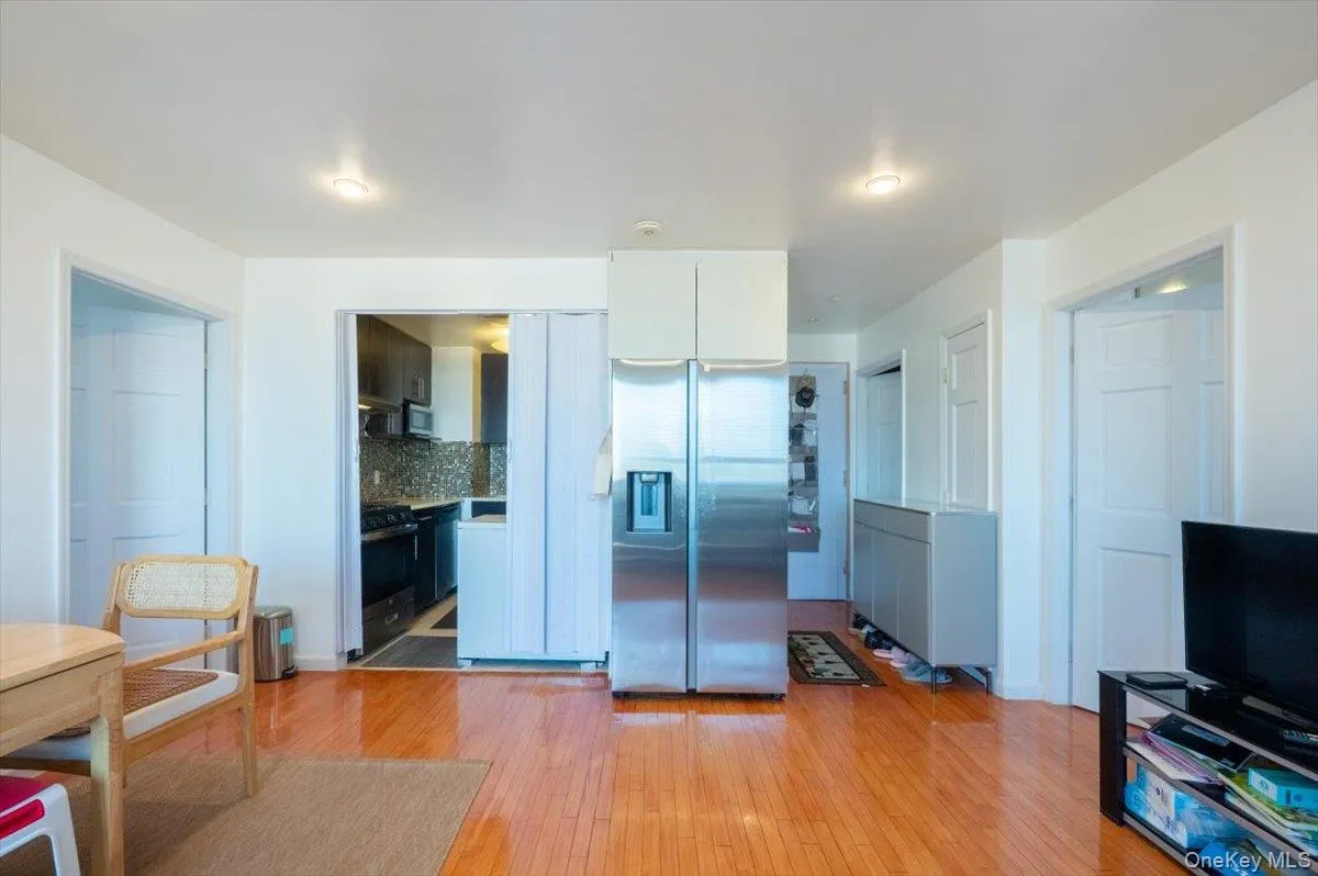 Kitchen with stainless steel fridge with ice dispenser, light wood-style floors, backsplash, range with gas stovetop, and white cabinets Kitchen with stainless steel fridge with ice dispenser, light wood-style floors, backsplash, range with gas stovetop, and white cabinets