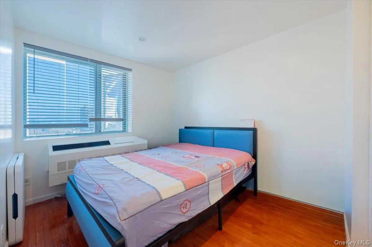 Bedroom featuring wood finished floors and radiator Bedroom featuring wood finished floors and radiator