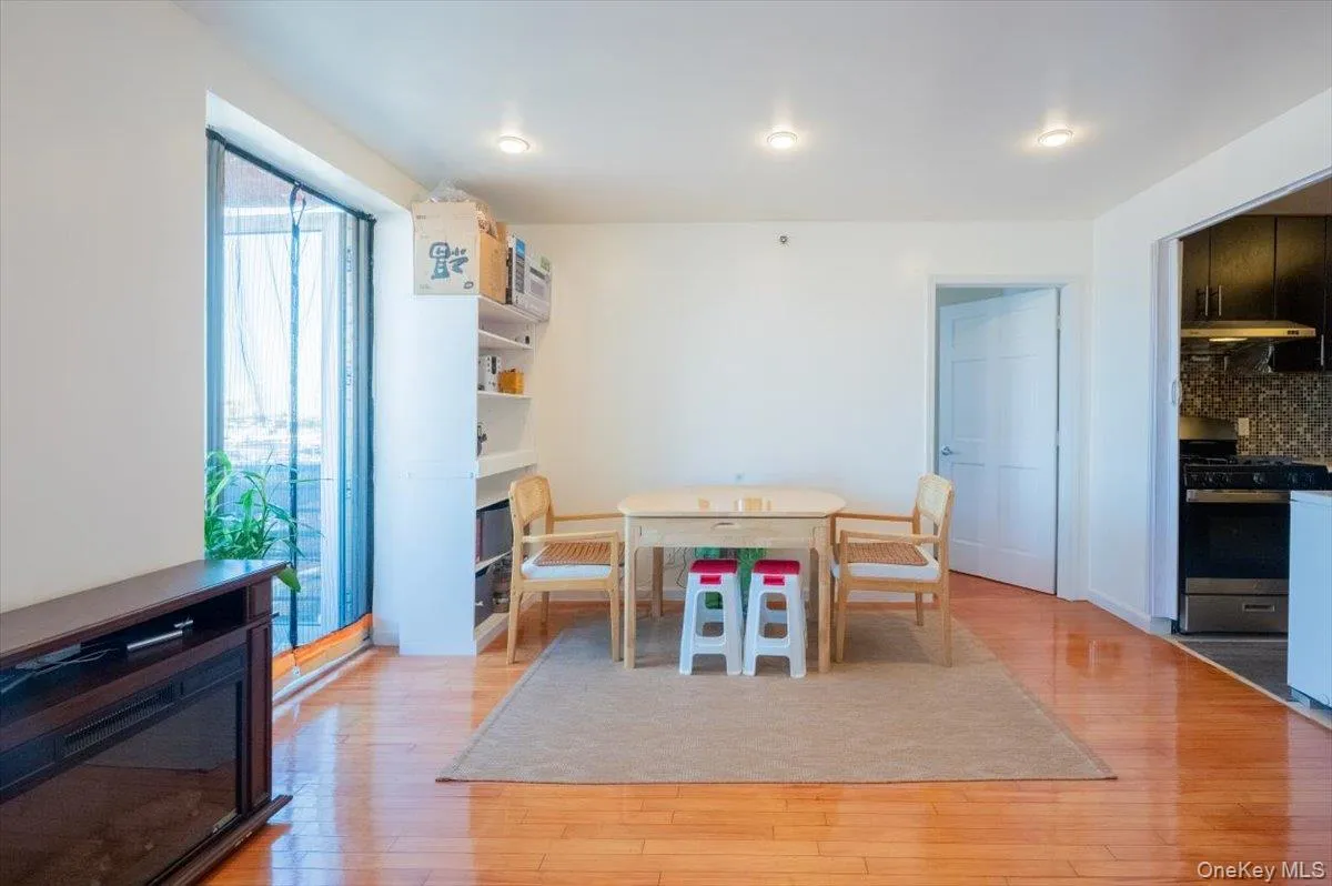 Dining space with light wood finished floors and a glass covered fireplace Dining space with light wood finished floors and a glass covered fireplace