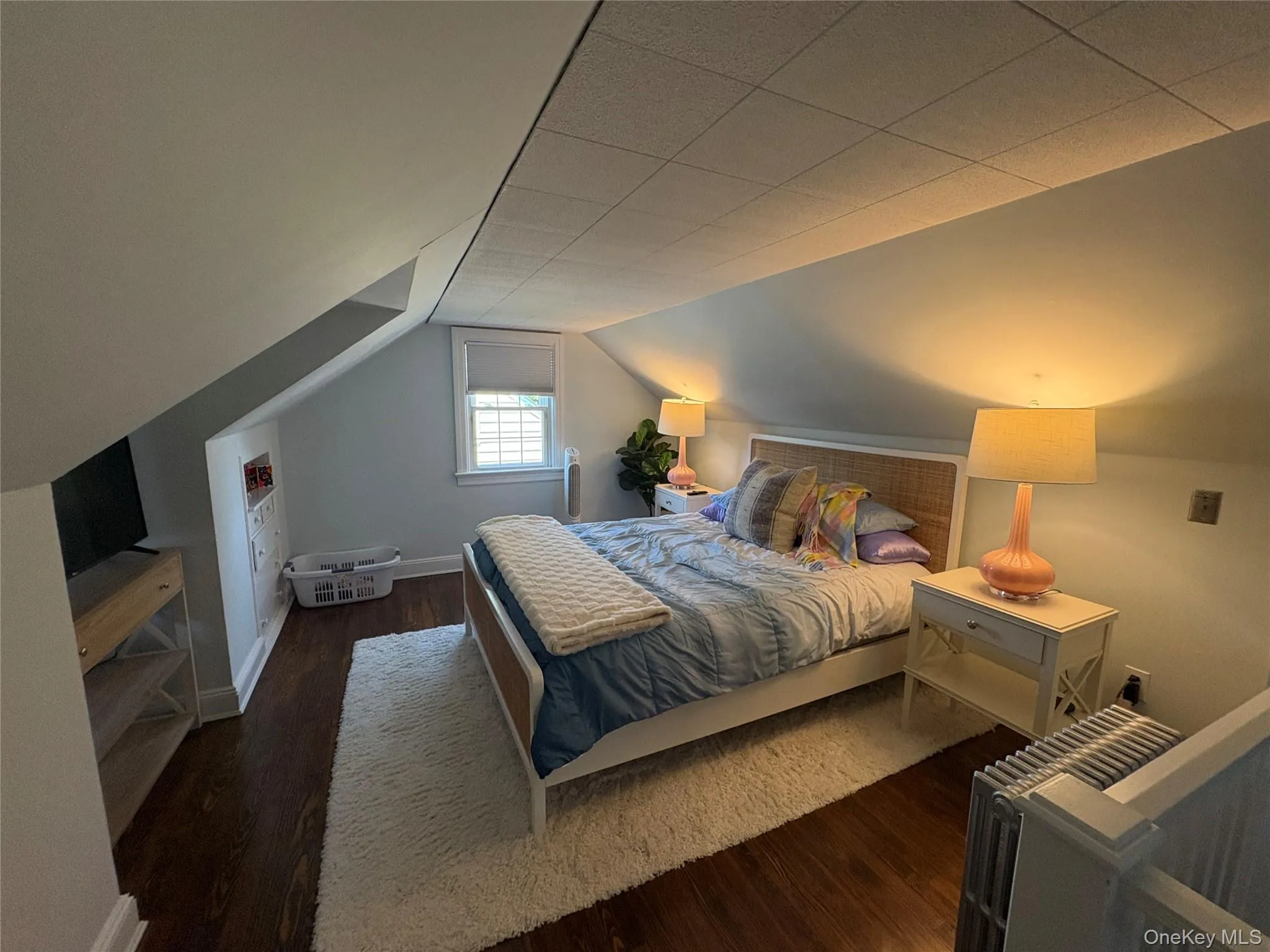 Primary Bedroom featuring wood finished floors and lofted ceiling Primary Bedroom featuring wood finished floors and lofted ceiling
