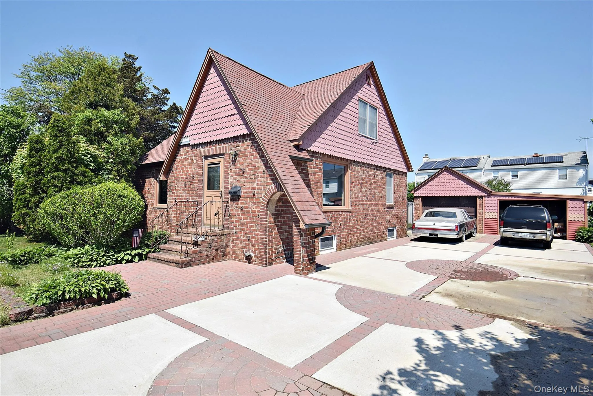 Side View shows Beautiful Brick Tudor & Massive Driveway & Garage Side View shows Beautiful Brick Tudor & Massive Driveway & Garage