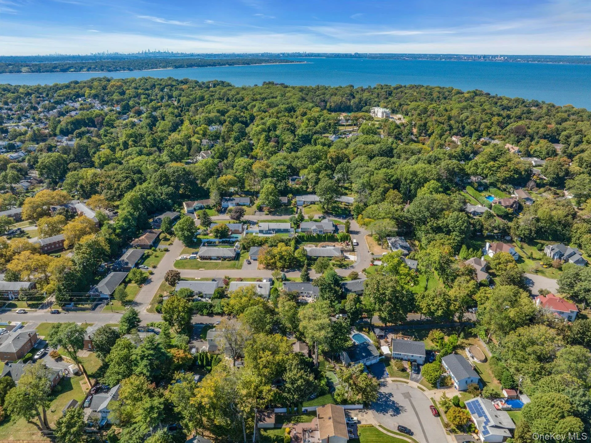 Aerial view of property's location featuring nearby suburban area and a large body of water Aerial view of property's location featuring nearby suburban area and a large body of water