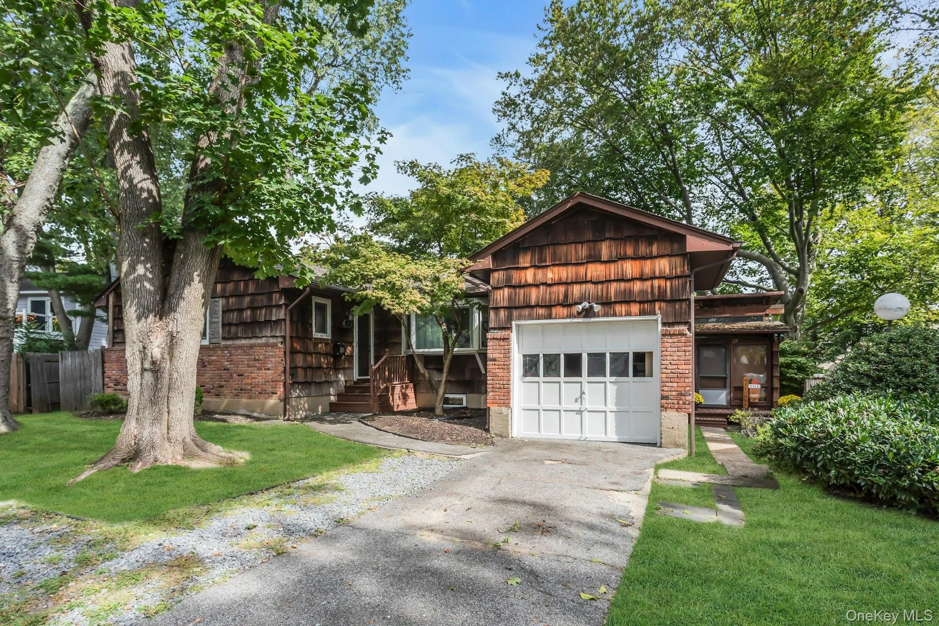 View of front of home with a front lawn, asphalt driveway, and a garage View of front of home with a front lawn, asphalt driveway, and a garage