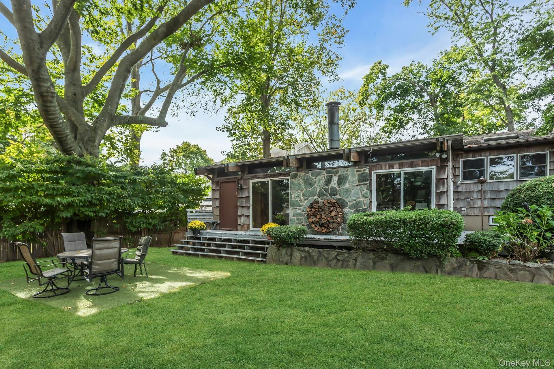 Back of house featuring a patio area and stone siding Back of house featuring a patio area and stone siding