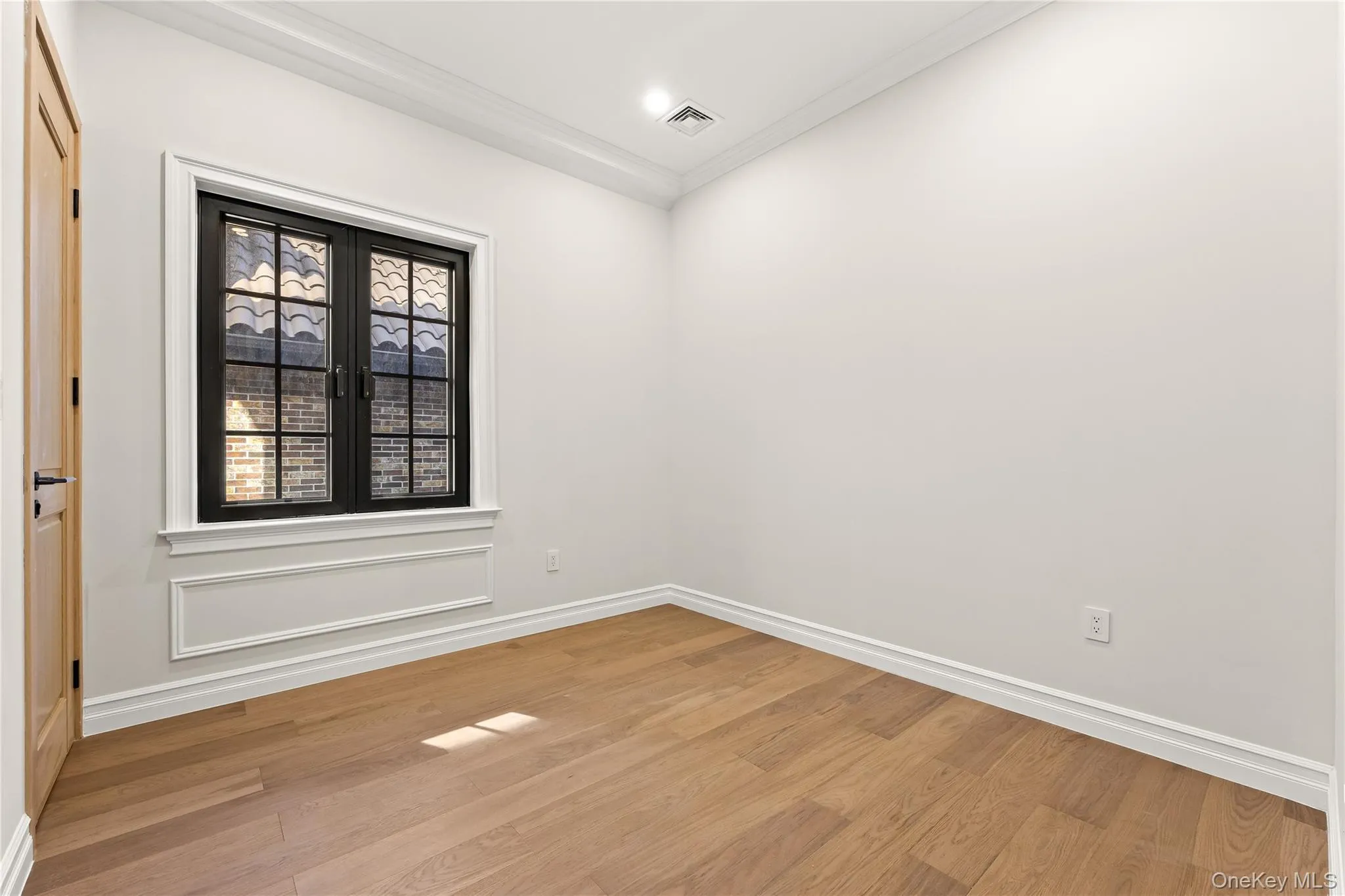 Unfurnished room with light wood-style floors and ornamental molding Unfurnished room with light wood-style floors and ornamental molding