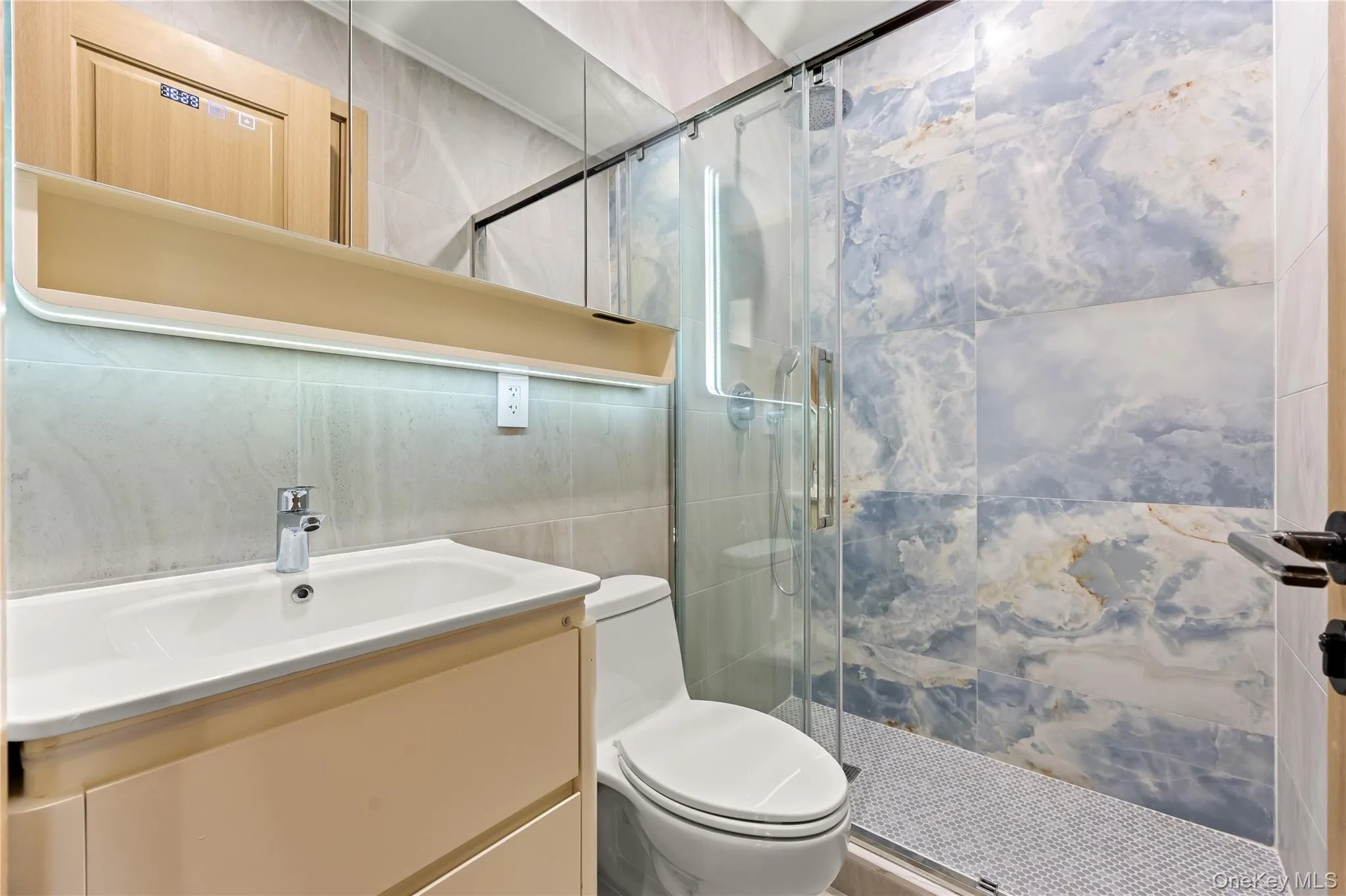 Full bath featuring vanity, a shower stall, and tile walls Full bath featuring vanity, a shower stall, and tile walls