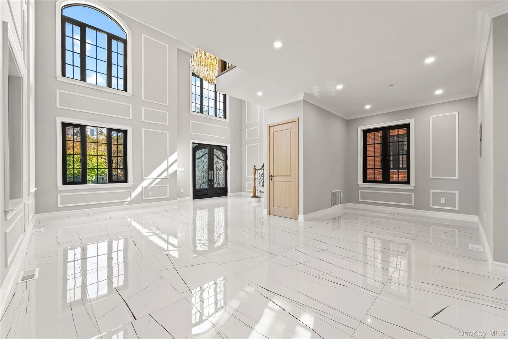 Entryway featuring recessed lighting, a chandelier, crown molding, light marble finish flooring, and french doors Entryway featuring recessed lighting, a chandelier, crown molding, light marble finish flooring, and french doors