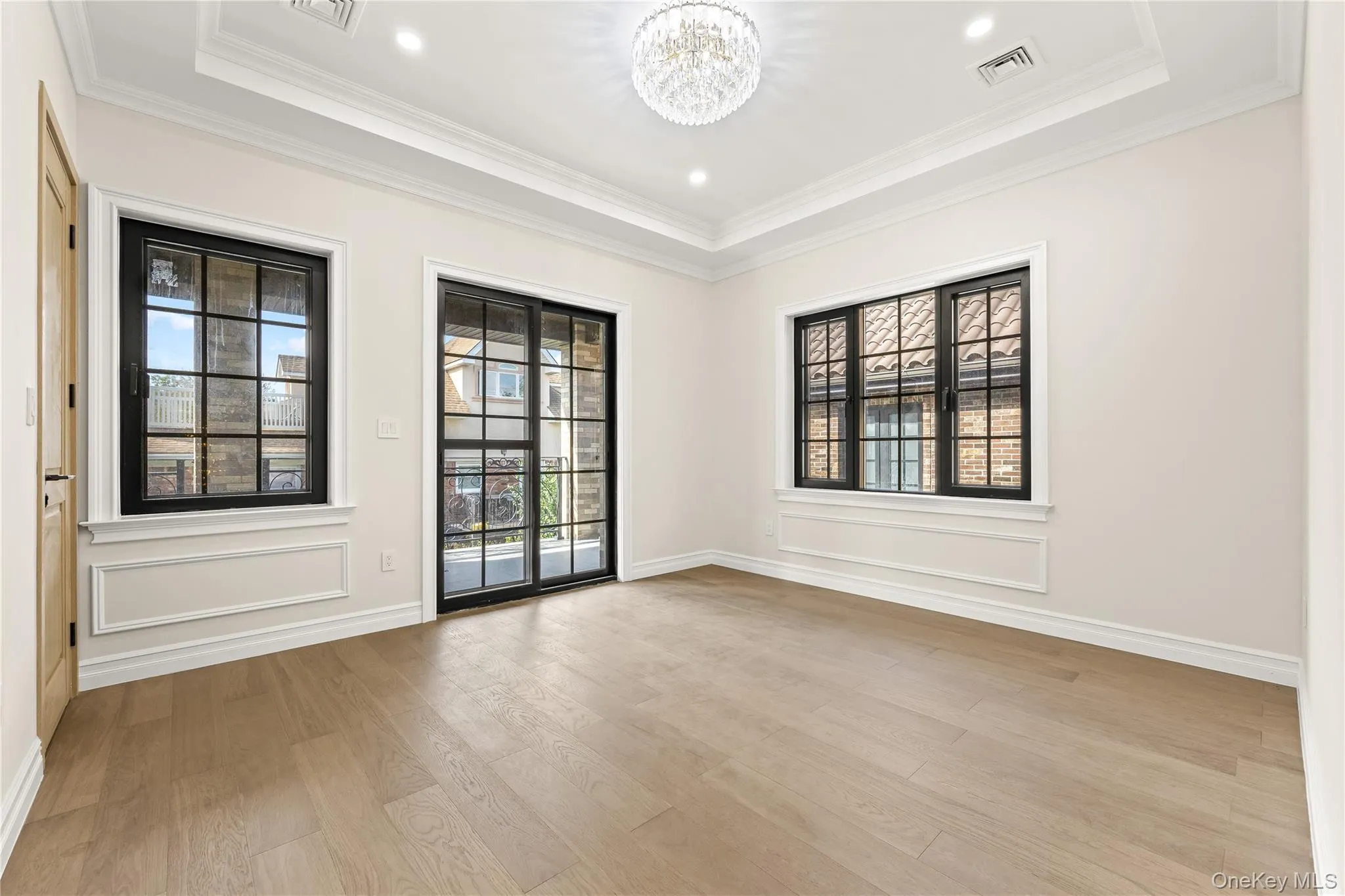 Unfurnished room featuring a chandelier, light wood-type flooring, a tray ceiling, crown molding, and recessed lighting Unfurnished room featuring a chandelier, light wood-type flooring, a tray ceiling, crown molding, and recessed lighting