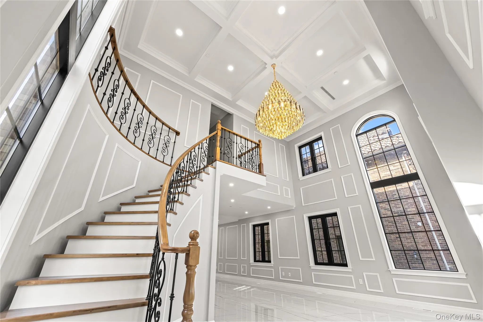 Stairs with a decorative wall, a chandelier, recessed lighting, a towering ceiling, and beam ceiling Stairs with a decorative wall, a chandelier, recessed lighting, a towering ceiling, and beam ceiling