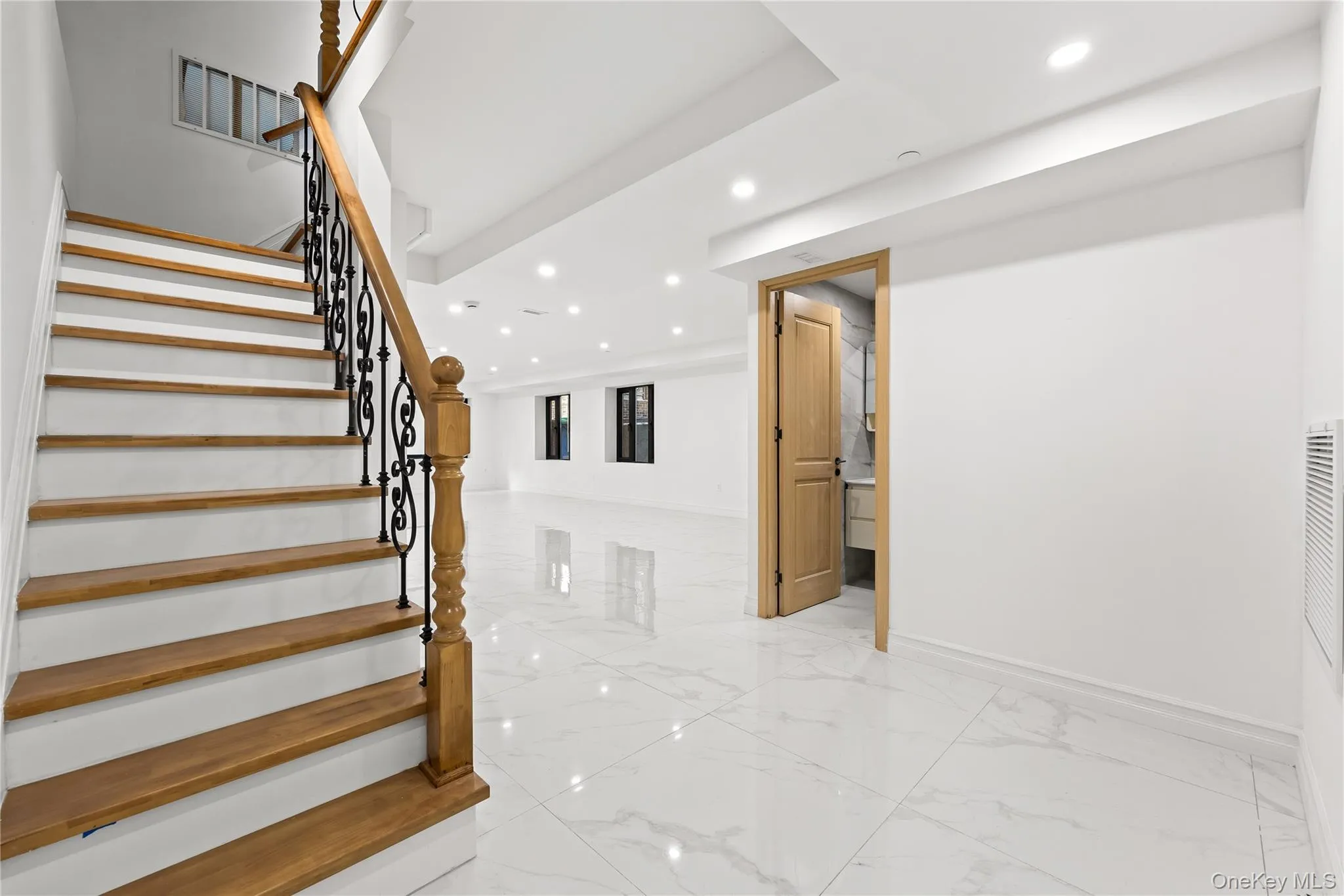 Stairs featuring recessed lighting and marble tiled flooring Stairs featuring recessed lighting and marble tiled flooring