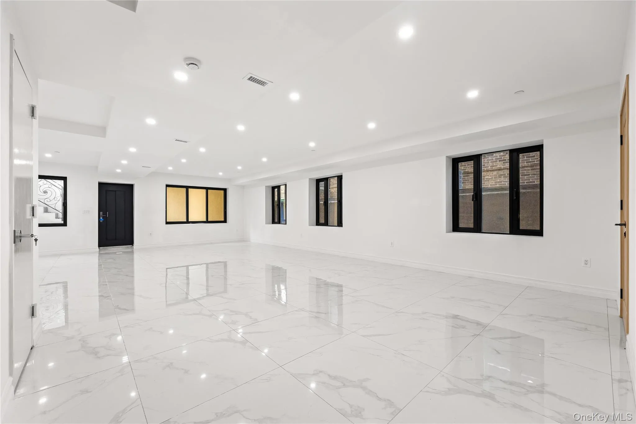 Spare room with light marble finish floors, plenty of natural light, and recessed lighting Spare room with light marble finish floors, plenty of natural light, and recessed lighting