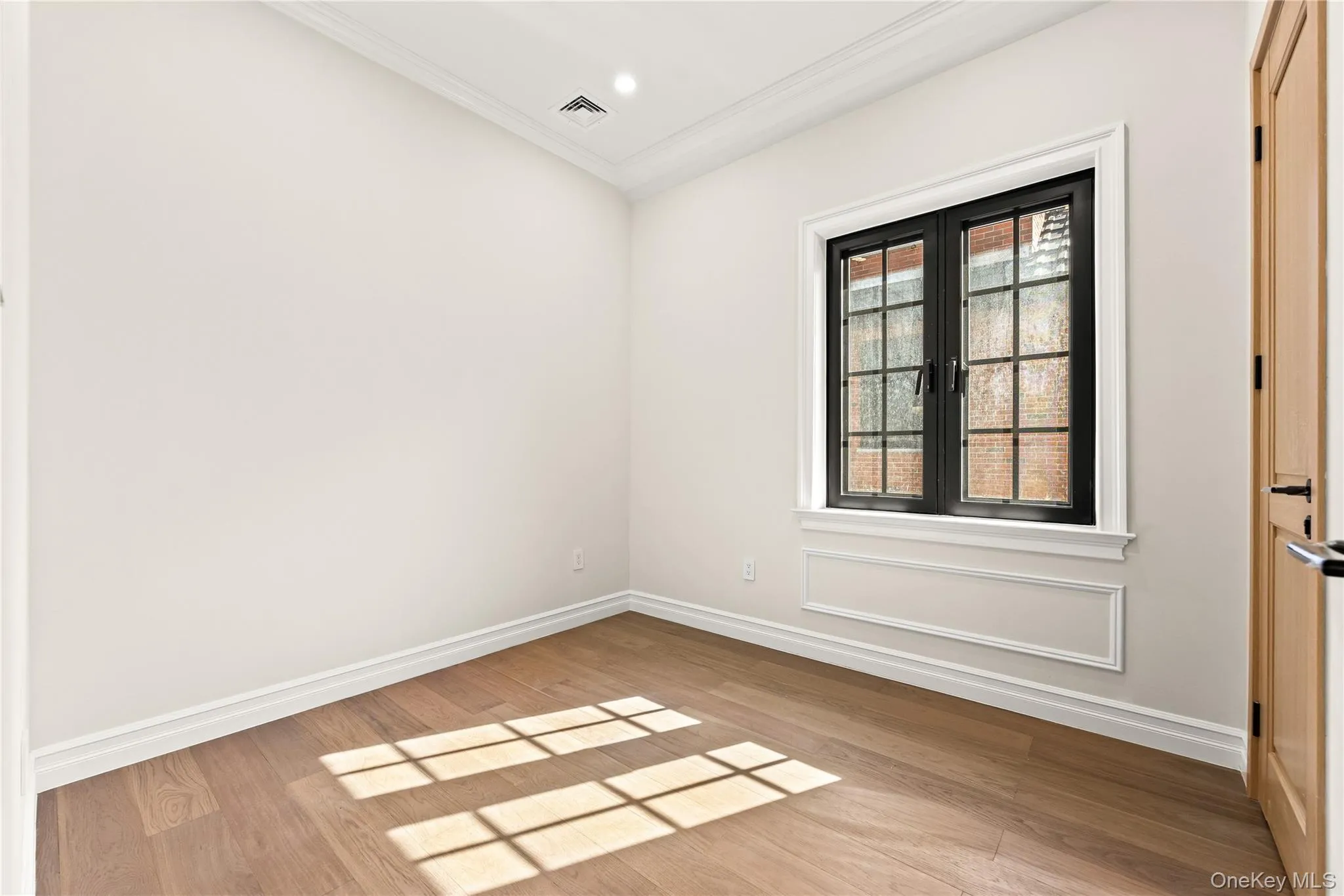 Unfurnished room featuring ornamental molding and light wood-type flooring Unfurnished room featuring ornamental molding and light wood-type flooring