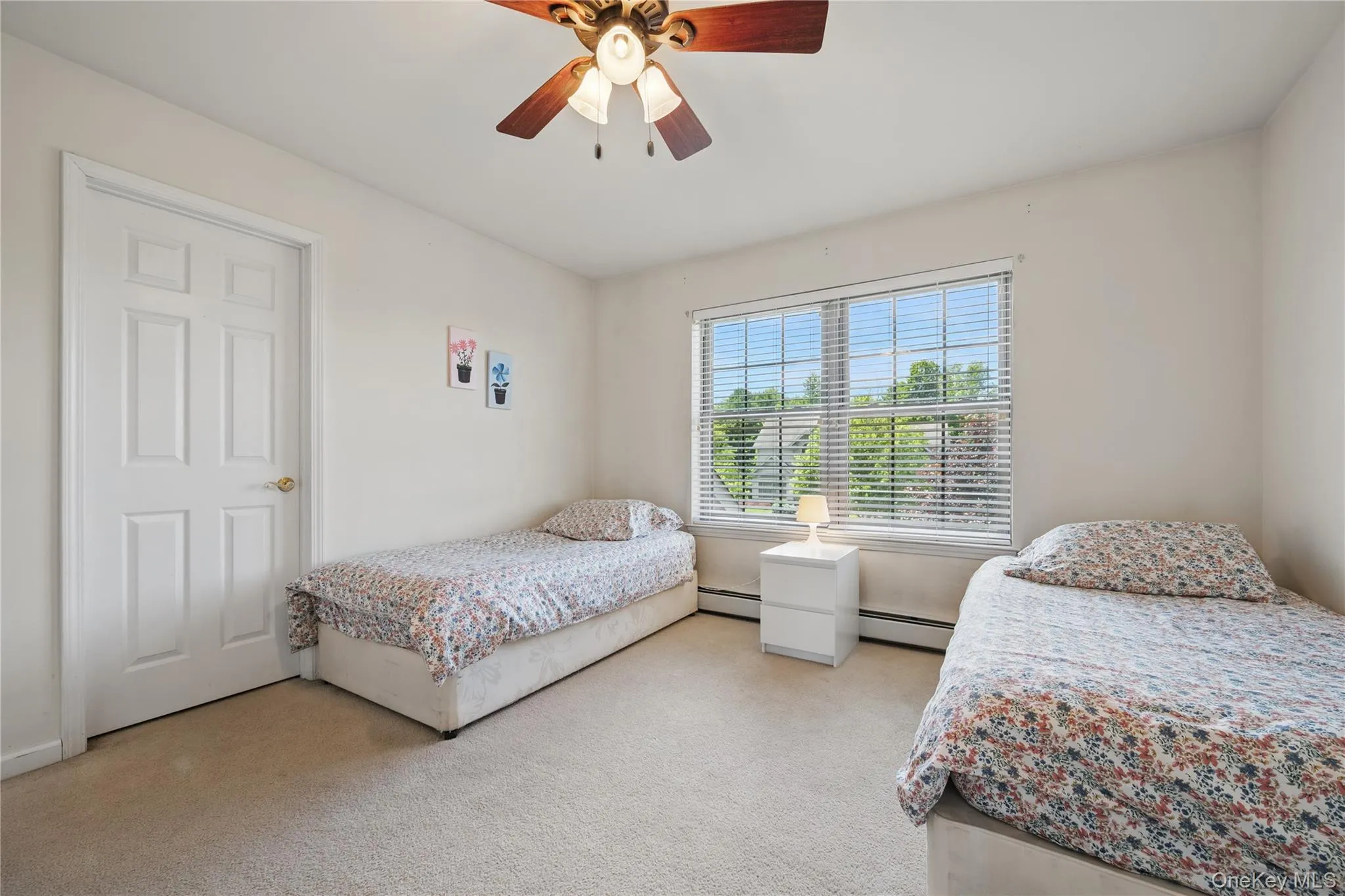 Bedroom featuring baseboard heating, carpet, and ceiling fan Bedroom featuring baseboard heating, carpet, and ceiling fan