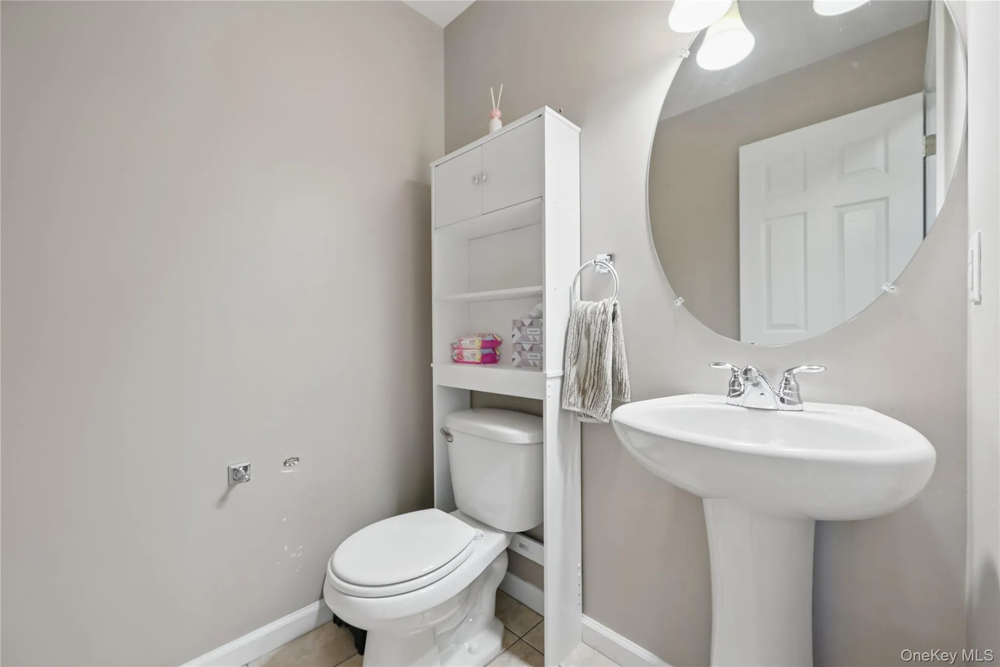 Half bathroom with toilet, tile patterned floors, baseboards, and a sink Half bathroom with toilet, tile patterned floors, baseboards, and a sink