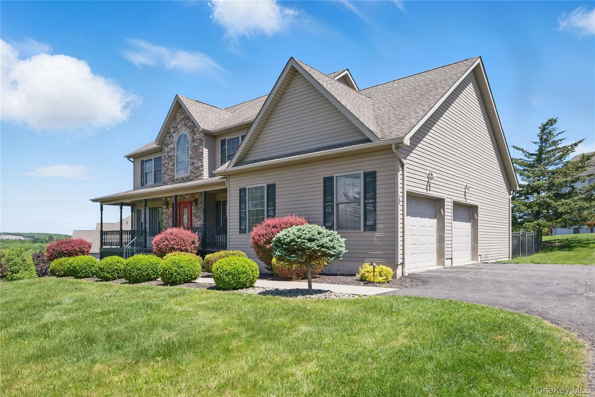 View of front of house with asphalt driveway, a front lawn, an attached garage, a porch, and a shingled roof View of front of house with asphalt driveway, a front lawn, an attached garage, a porch, and a shingled roof