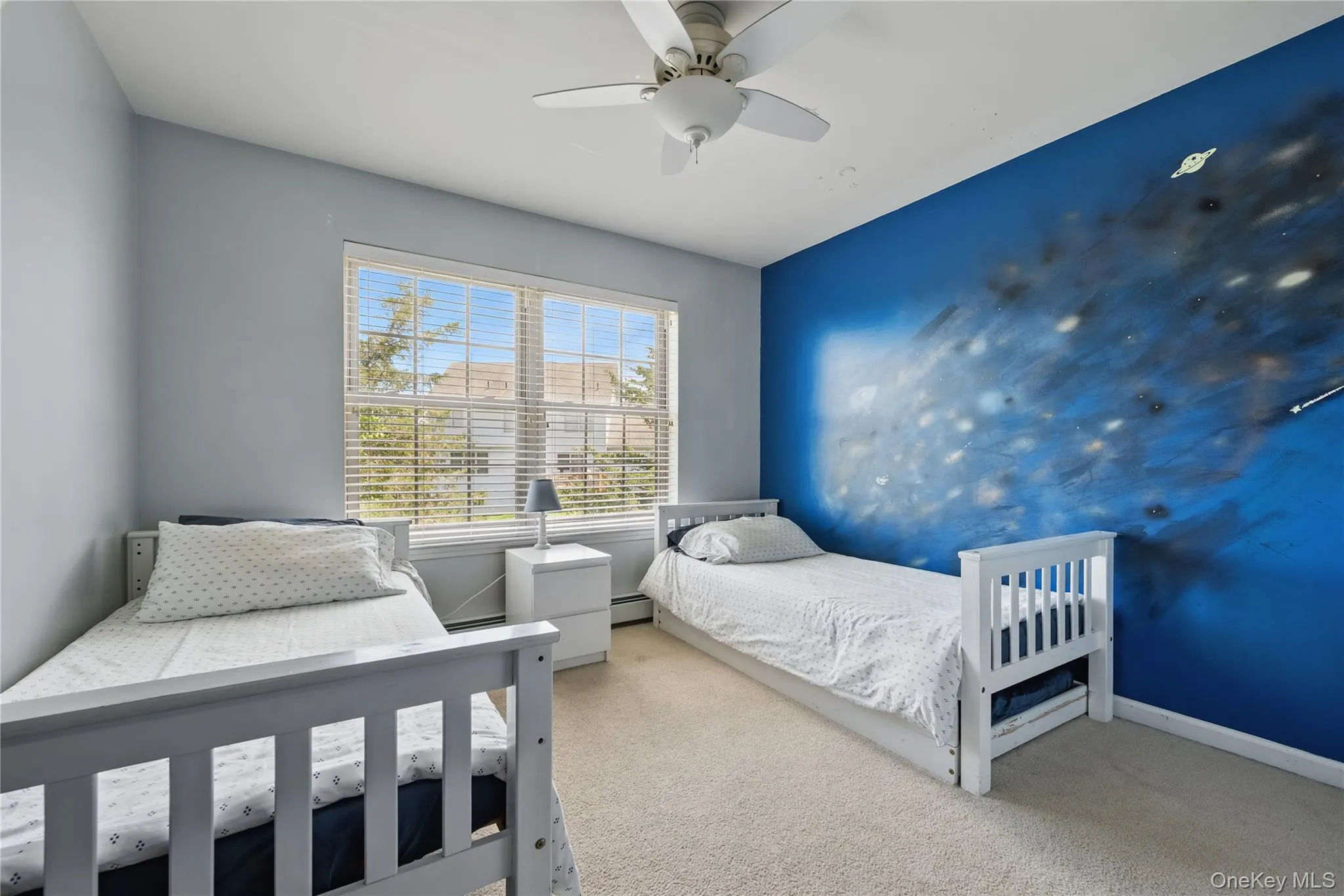 Bedroom featuring carpet, a baseboard heating unit, a ceiling fan, and baseboards Bedroom featuring carpet, a baseboard heating unit, a ceiling fan, and baseboards