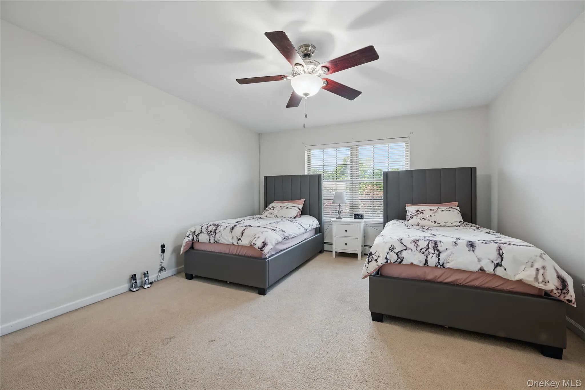 Bedroom with light carpet, ceiling fan, and baseboards Bedroom with light carpet, ceiling fan, and baseboards