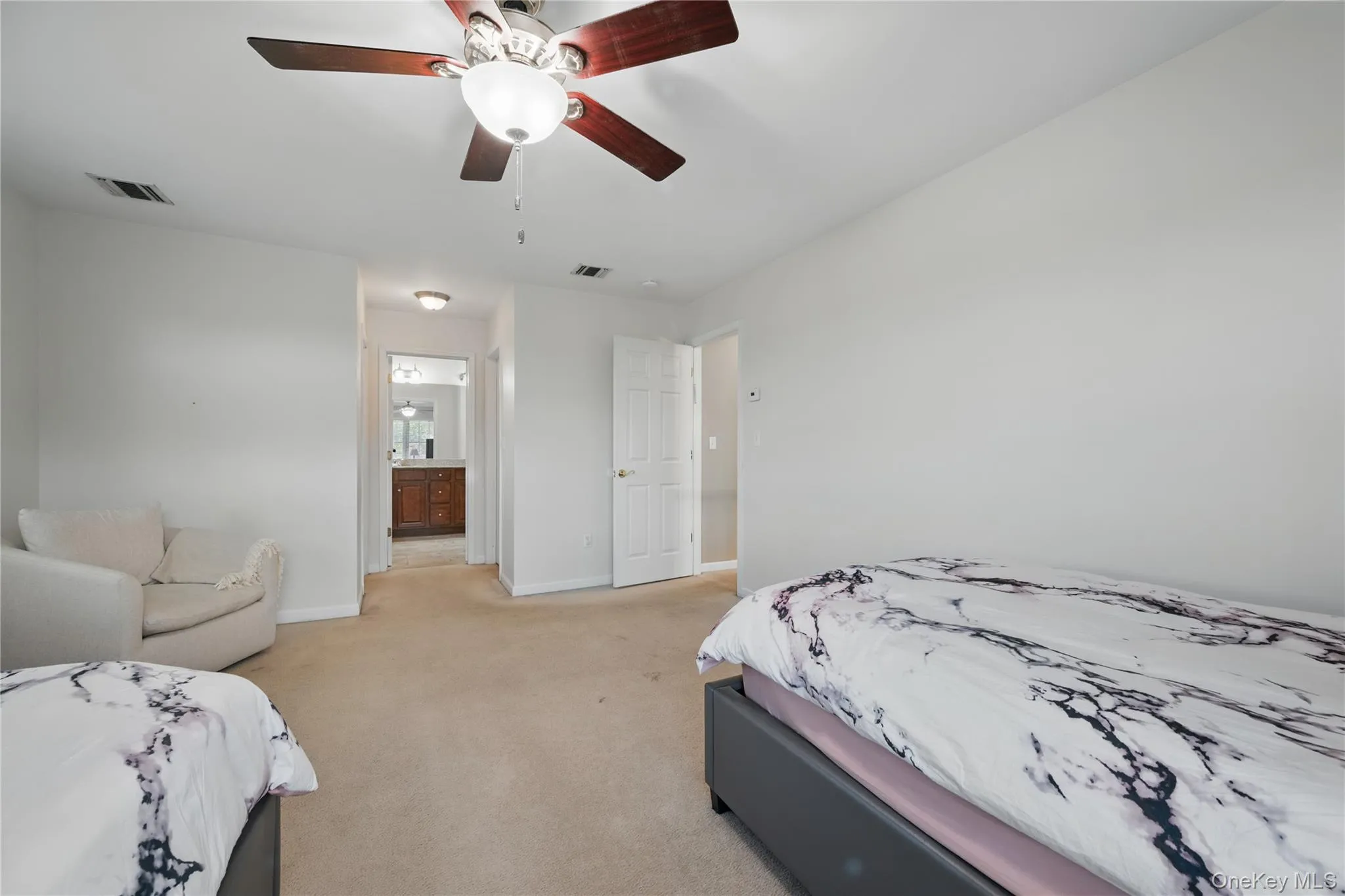 Bedroom featuring light carpet, baseboards, a ceiling fan, and ensuite bath Bedroom featuring light carpet, baseboards, a ceiling fan, and ensuite bath