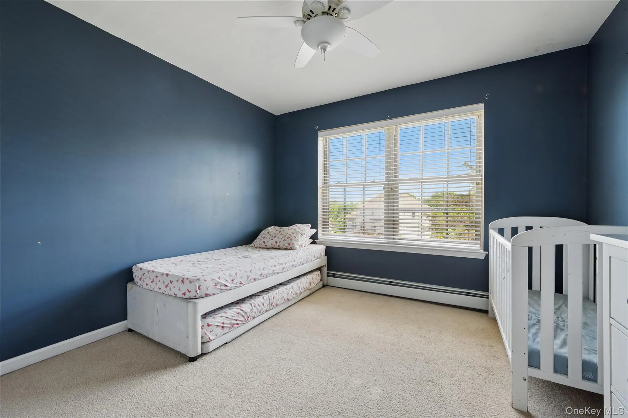 Carpeted bedroom with a baseboard heating unit, a ceiling fan, and baseboards Carpeted bedroom with a baseboard heating unit, a ceiling fan, and baseboards