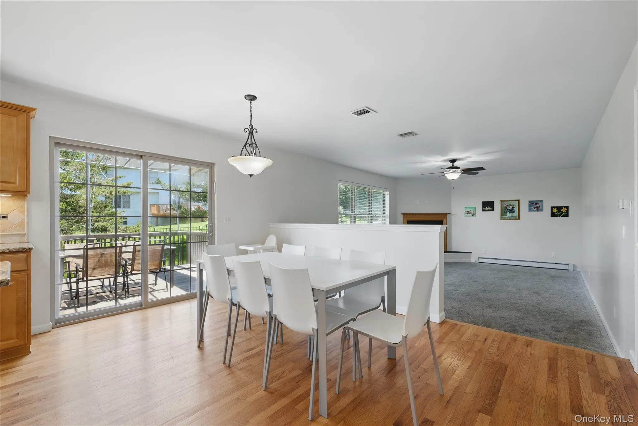 Dining area with ceiling fan, a baseboard heating unit, light wood-type flooring, and plenty of natural light Dining area with ceiling fan, a baseboard heating unit, light wood-type flooring, and plenty of natural light
