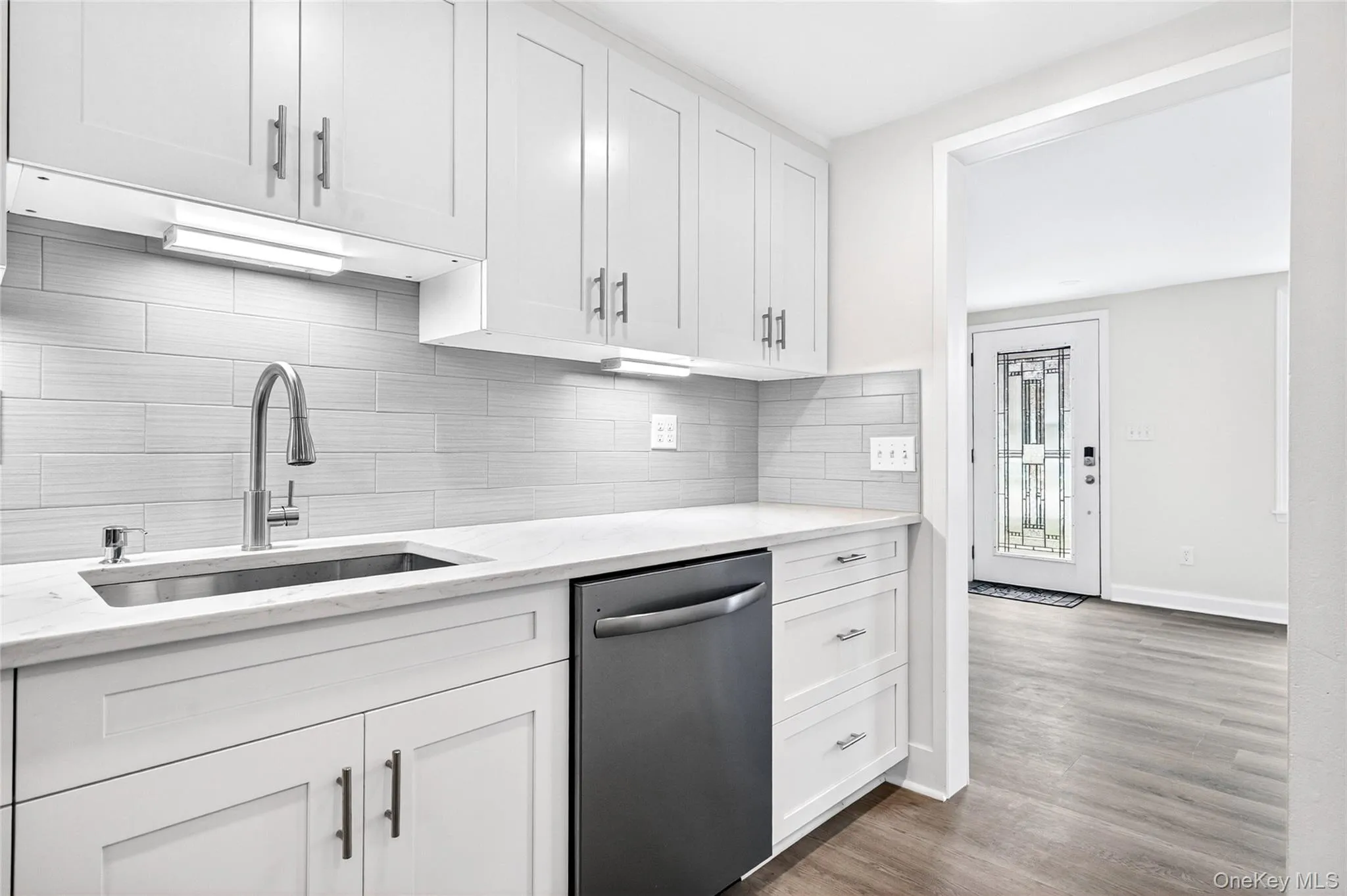 Updated kitchen featuring white cabinetry and stainless steel appliances Updated kitchen featuring white cabinetry and stainless steel appliances
