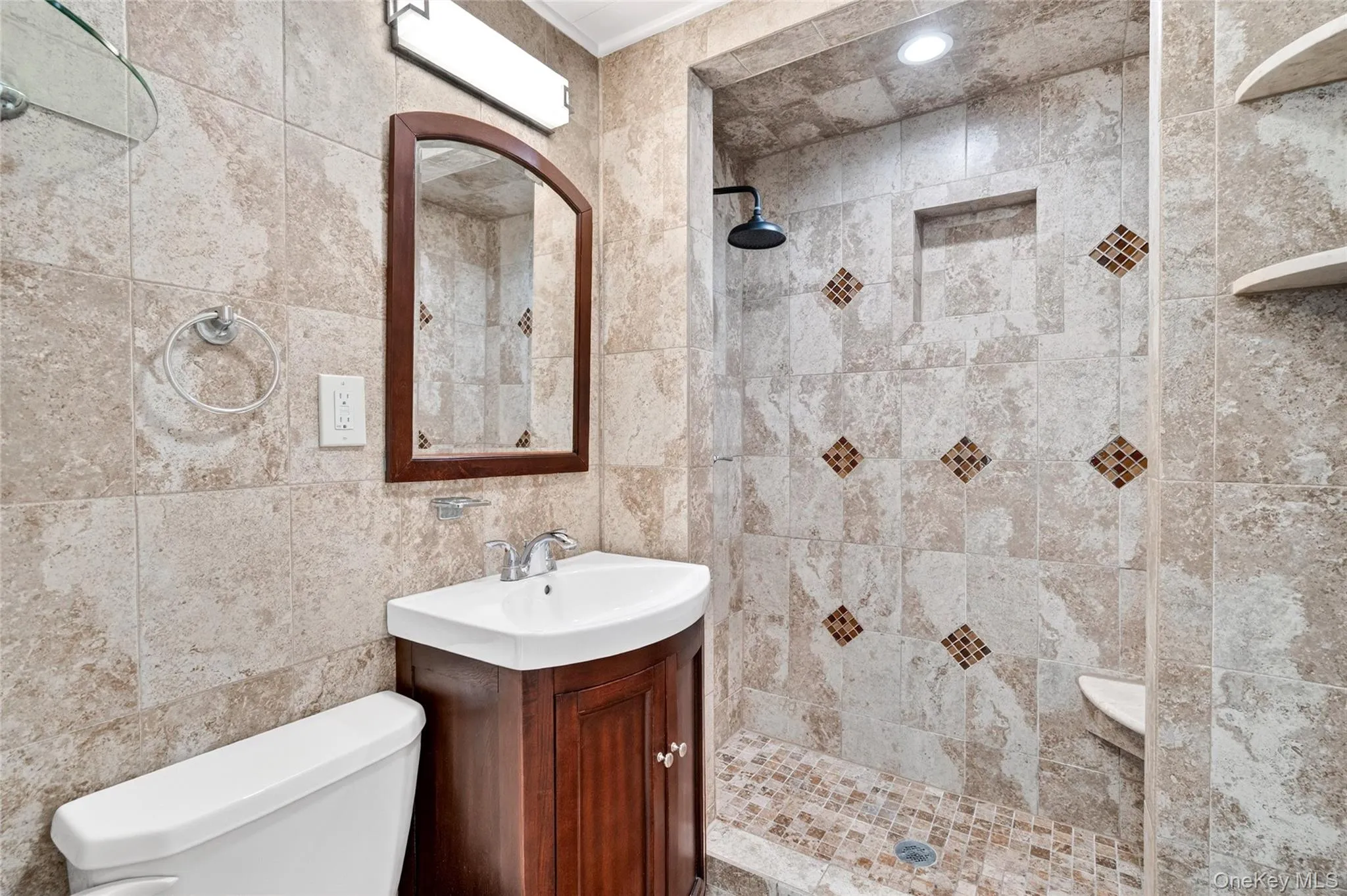 Renovated bathroom with custom tile shower and modern finishes Renovated bathroom with custom tile shower and modern finishes