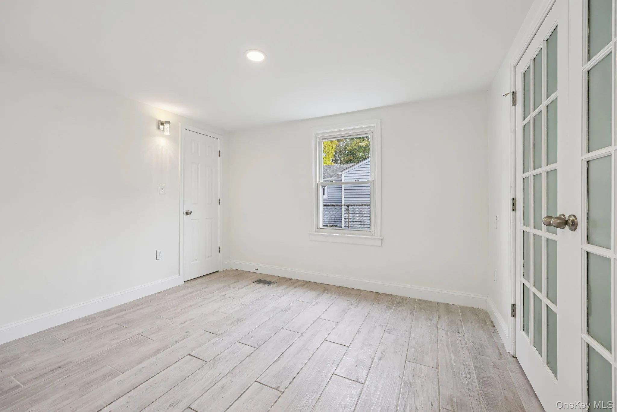 Versatile first floor bedroom or office featuring elegant French doors and updated flooring Versatile first floor bedroom or office featuring elegant French doors and updated flooring