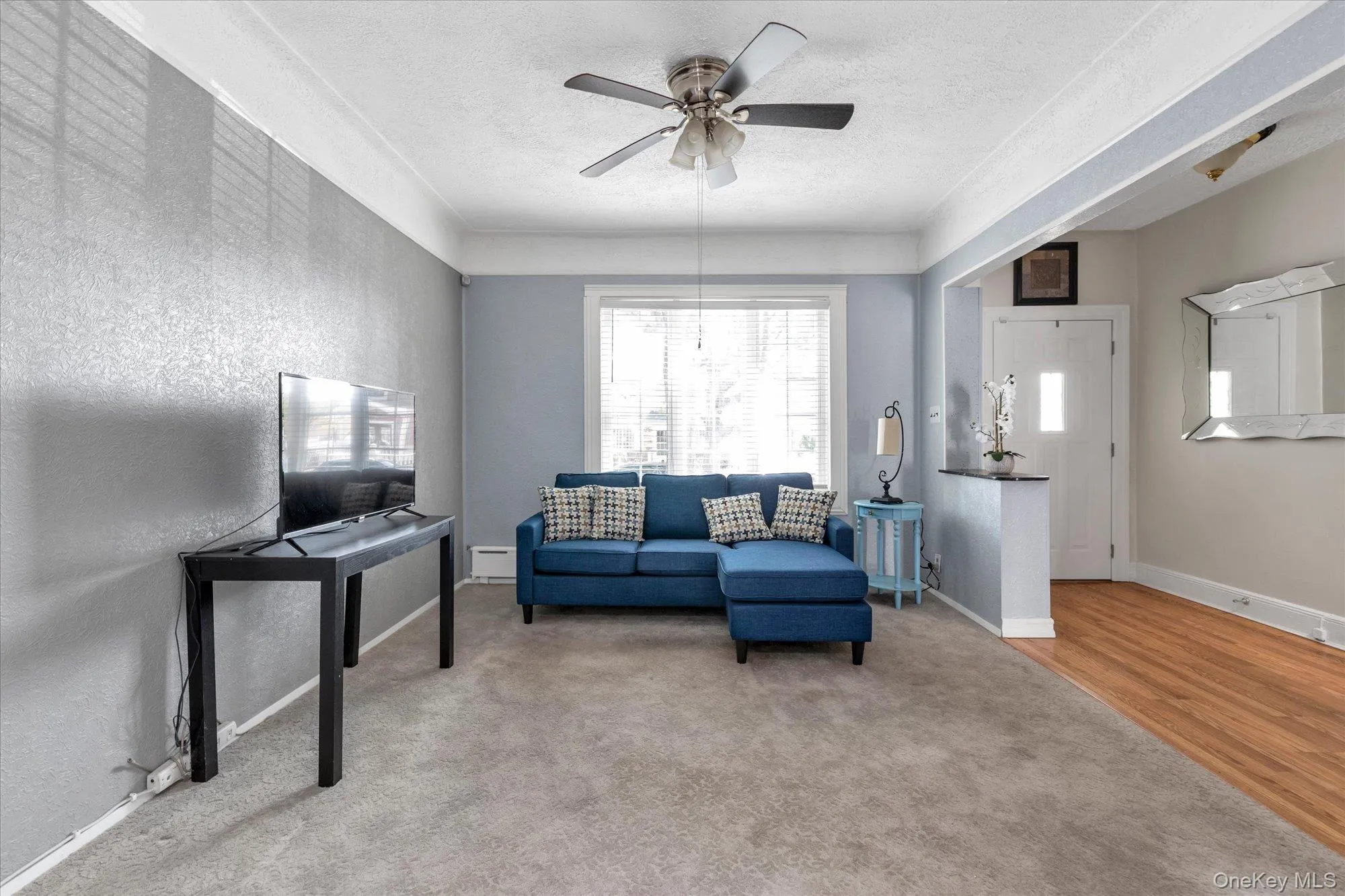 Living area with neutral carpeting, crown molding, and a ceiling fan Living area with neutral carpeting, crown molding, and a ceiling fan