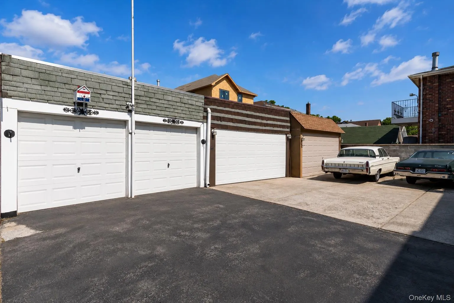 2 garage bays with white panel doors and shingle roofing 2 garage bays with white panel doors and shingle roofing