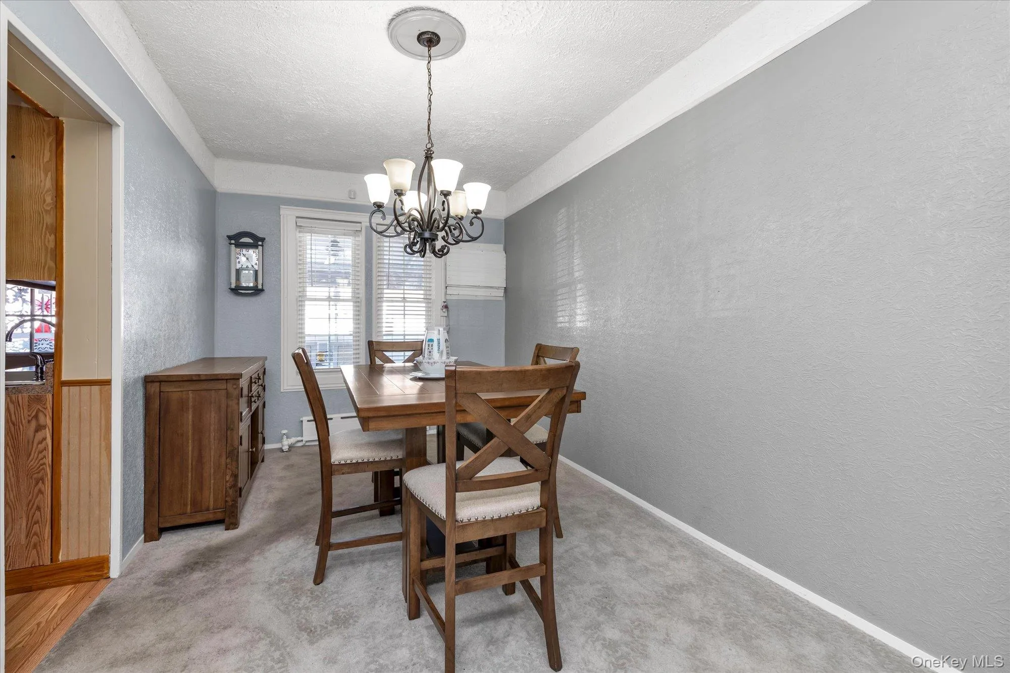 Formal dining space featuring light gray textured walls and white crown molding Formal dining space featuring light gray textured walls and white crown molding