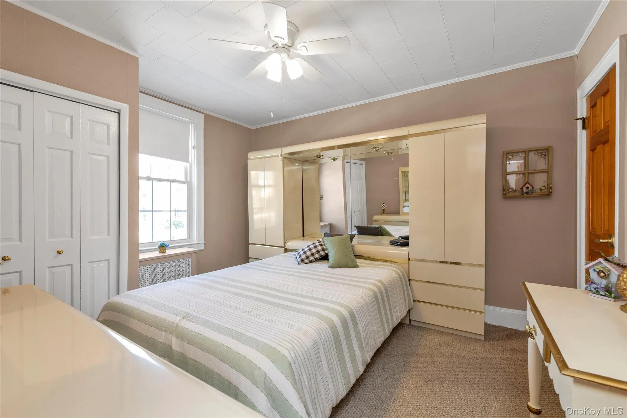 Room featuring wall-to-wall carpeting and a white ceiling fan with integrated lighting Room featuring wall-to-wall carpeting and a white ceiling fan with integrated lighting