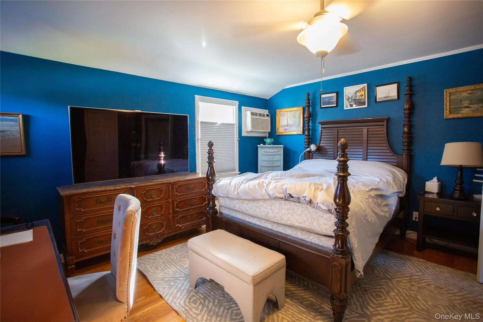 Bedroom with wood finished floors, ceiling fan, an AC wall unit, and crown molding Bedroom with wood finished floors, ceiling fan, an AC wall unit, and crown molding