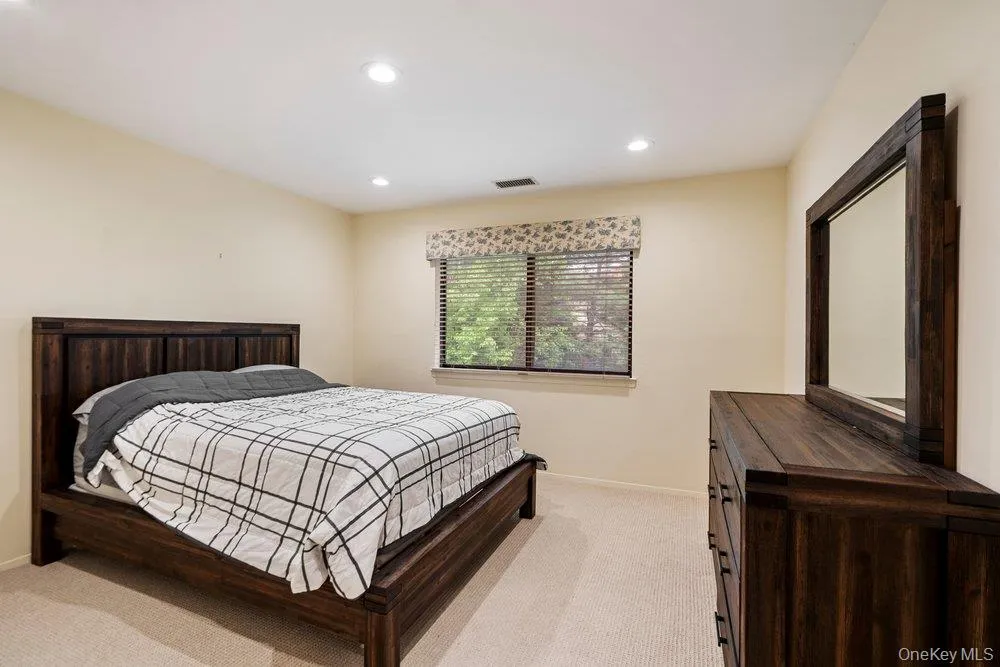 Carpeted room featuring recessed lighting, a window with blinds, and light-colored walls Carpeted room featuring recessed lighting, a window with blinds, and light-colored walls