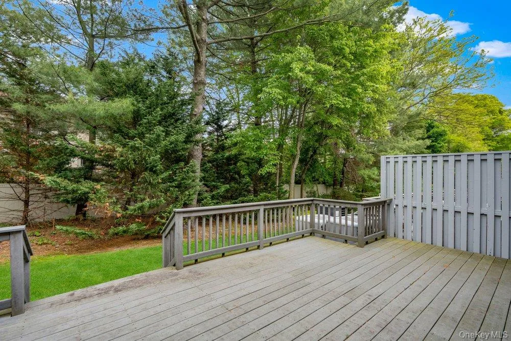 Spacious outdoor deck with natural wood-finish flooring and matching railings Spacious outdoor deck with natural wood-finish flooring and matching railings