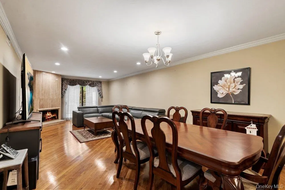 Hardwood flooring spans this open-concept room, featuring recessed lighting and crown molding Hardwood flooring spans this open-concept room, featuring recessed lighting and crown molding