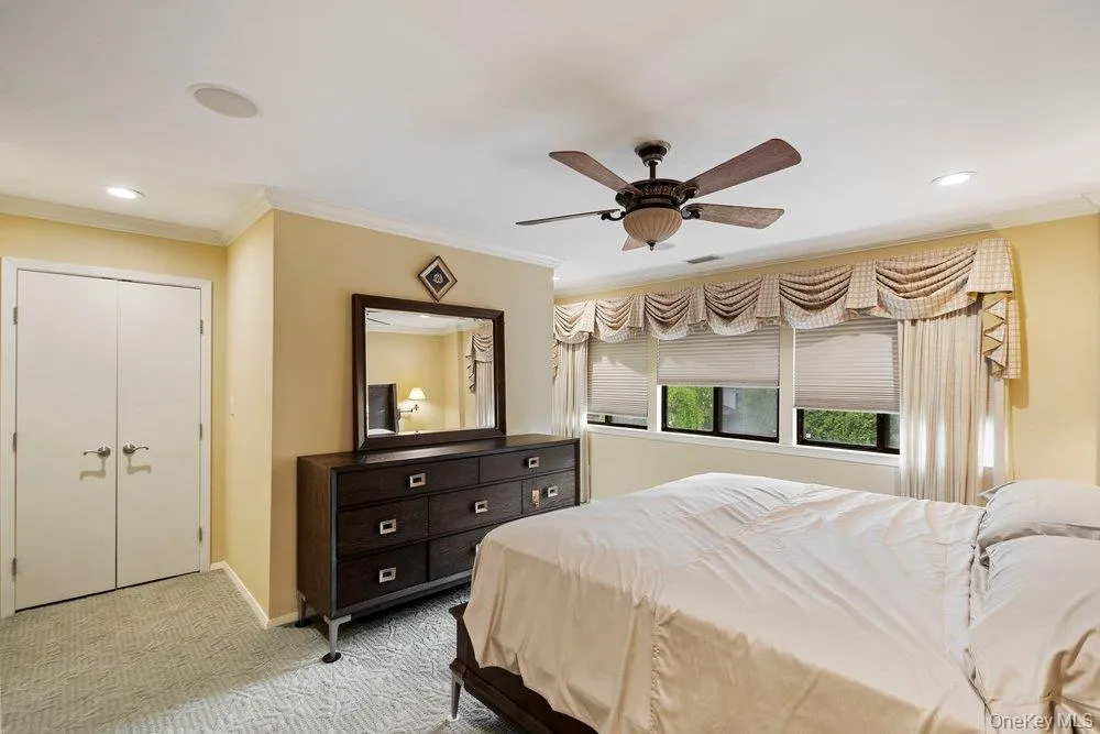 Recessed lighting, crown molding, and a ceiling fan fixture complement the room's design Recessed lighting, crown molding, and a ceiling fan fixture complement the room's design
