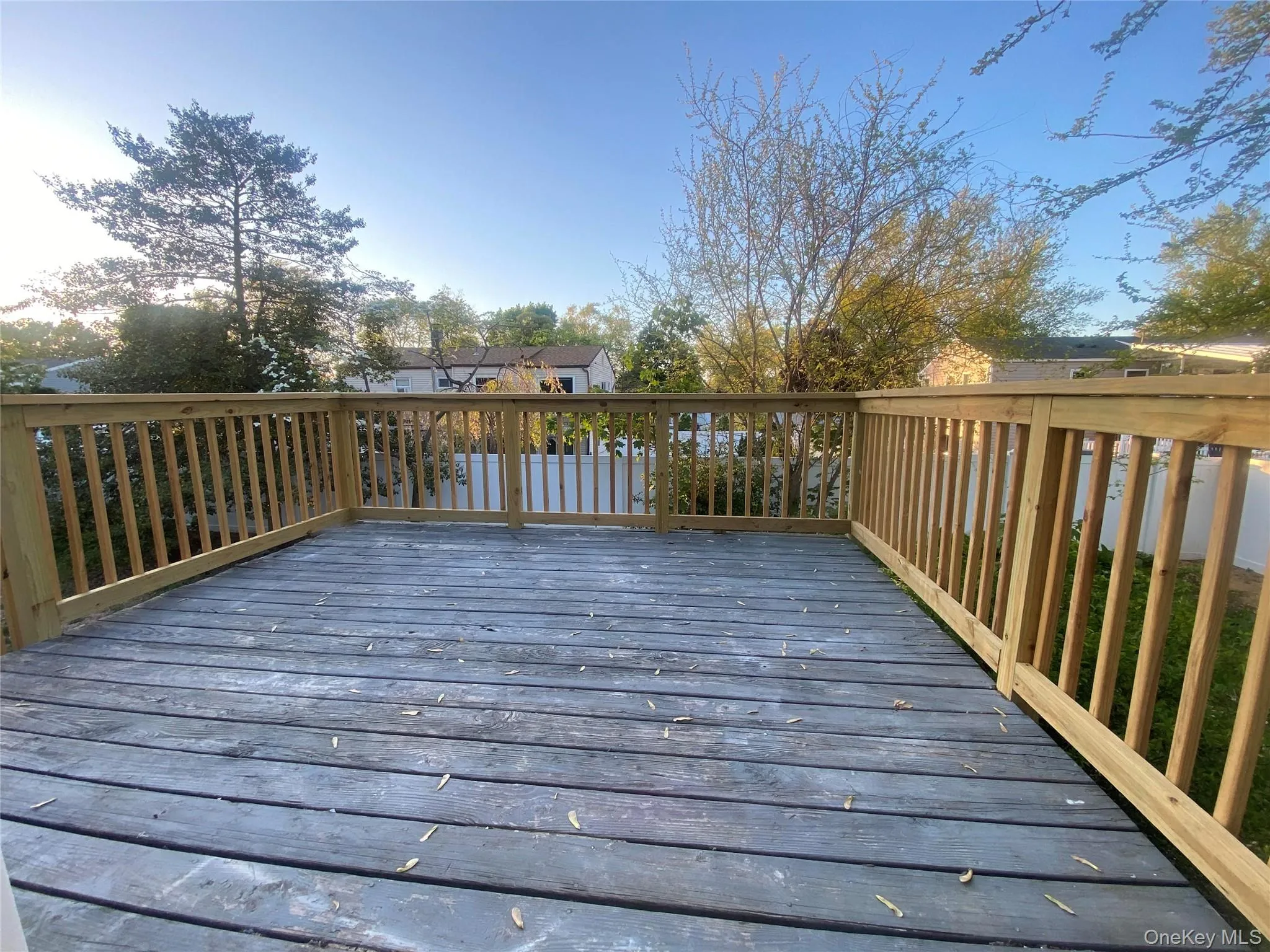 Spacious outdoor deck with natural wood railing and a durable wood-finish surface Spacious outdoor deck with natural wood railing and a durable wood-finish surface