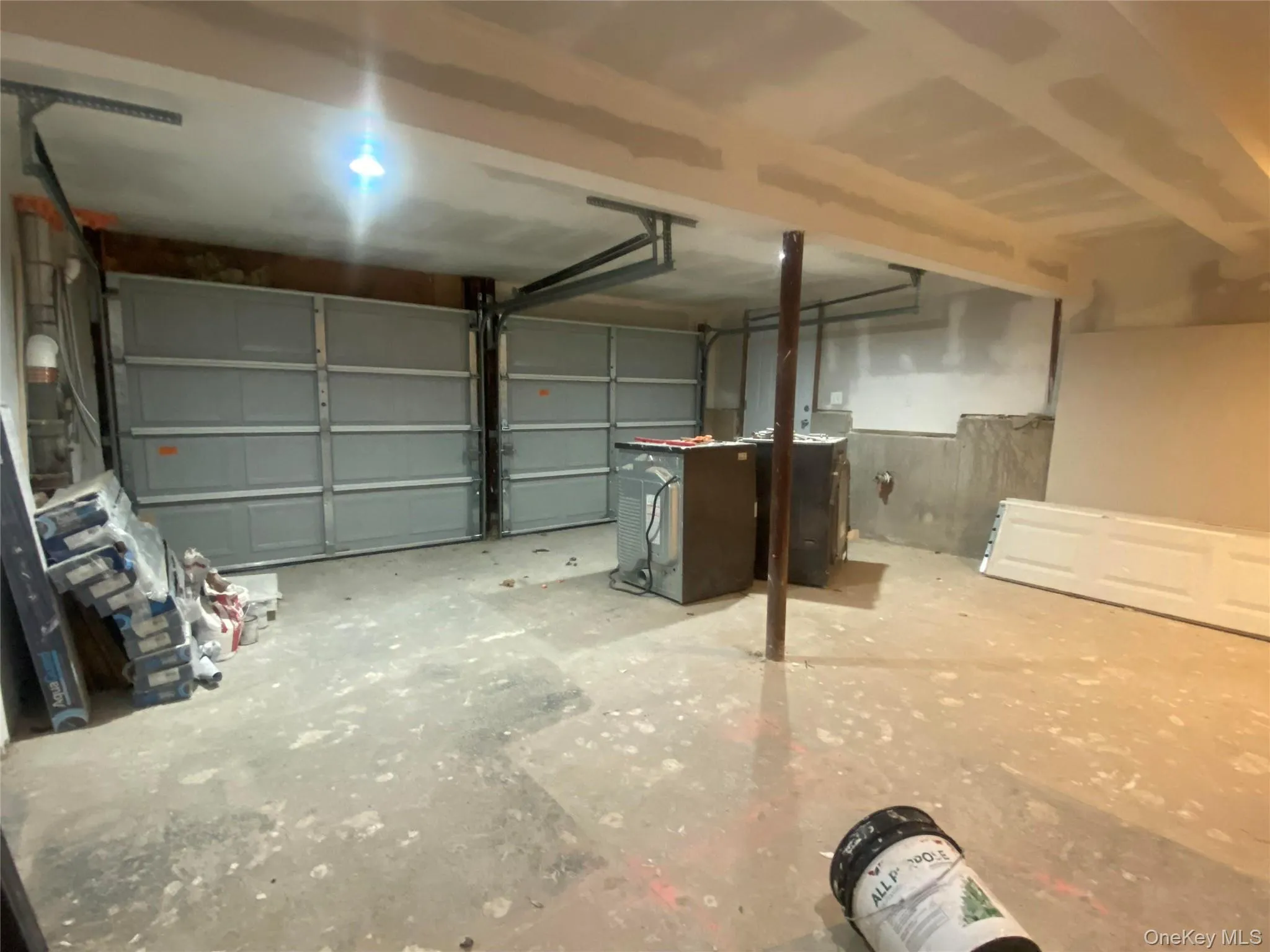 Garage space featuring two panel garage doors and a concrete floor Garage space featuring two panel garage doors and a concrete floor