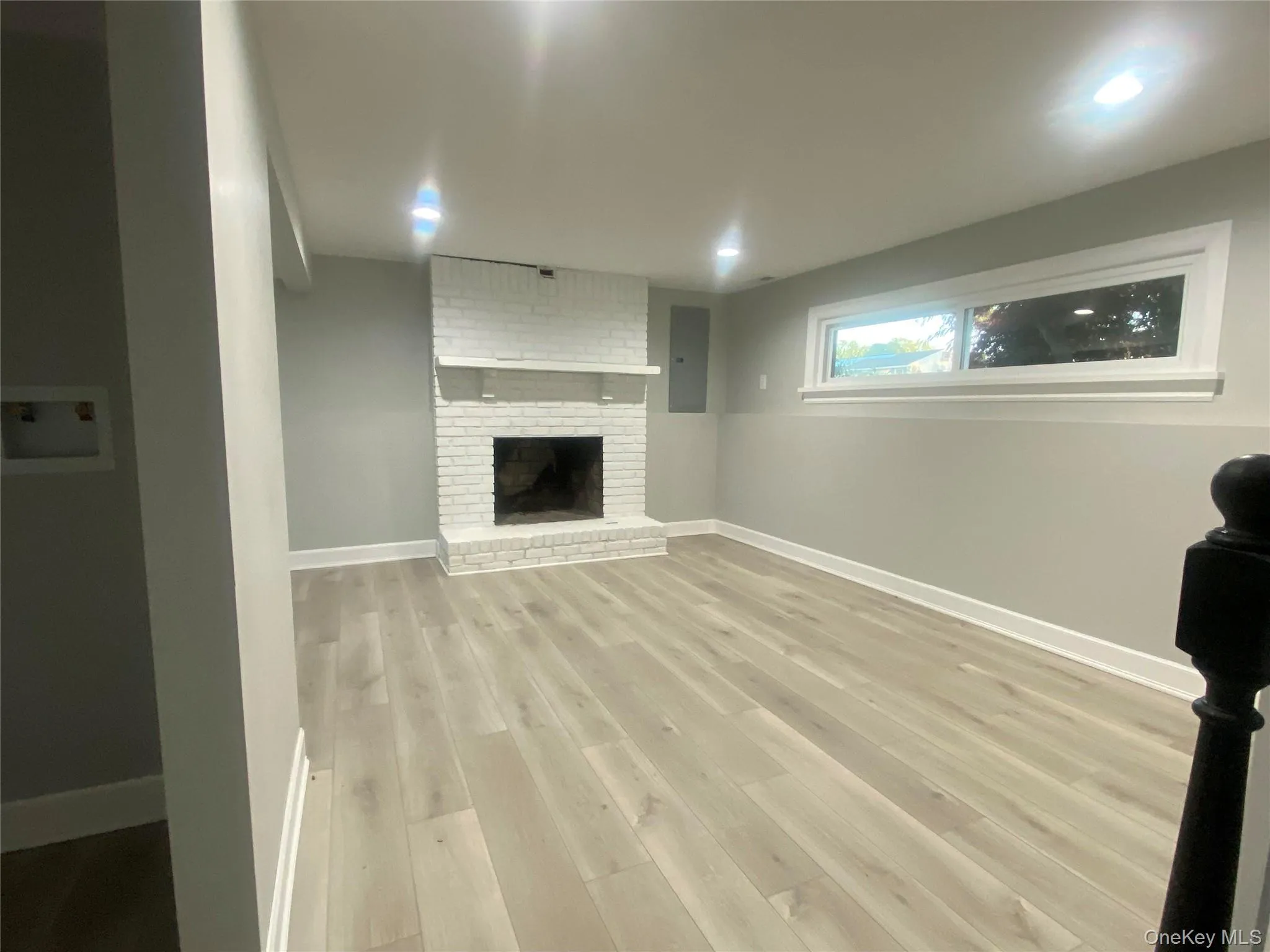 Den featuring white brick fireplace with mantel and recessed lighting. Den featuring white brick fireplace with mantel and recessed lighting.