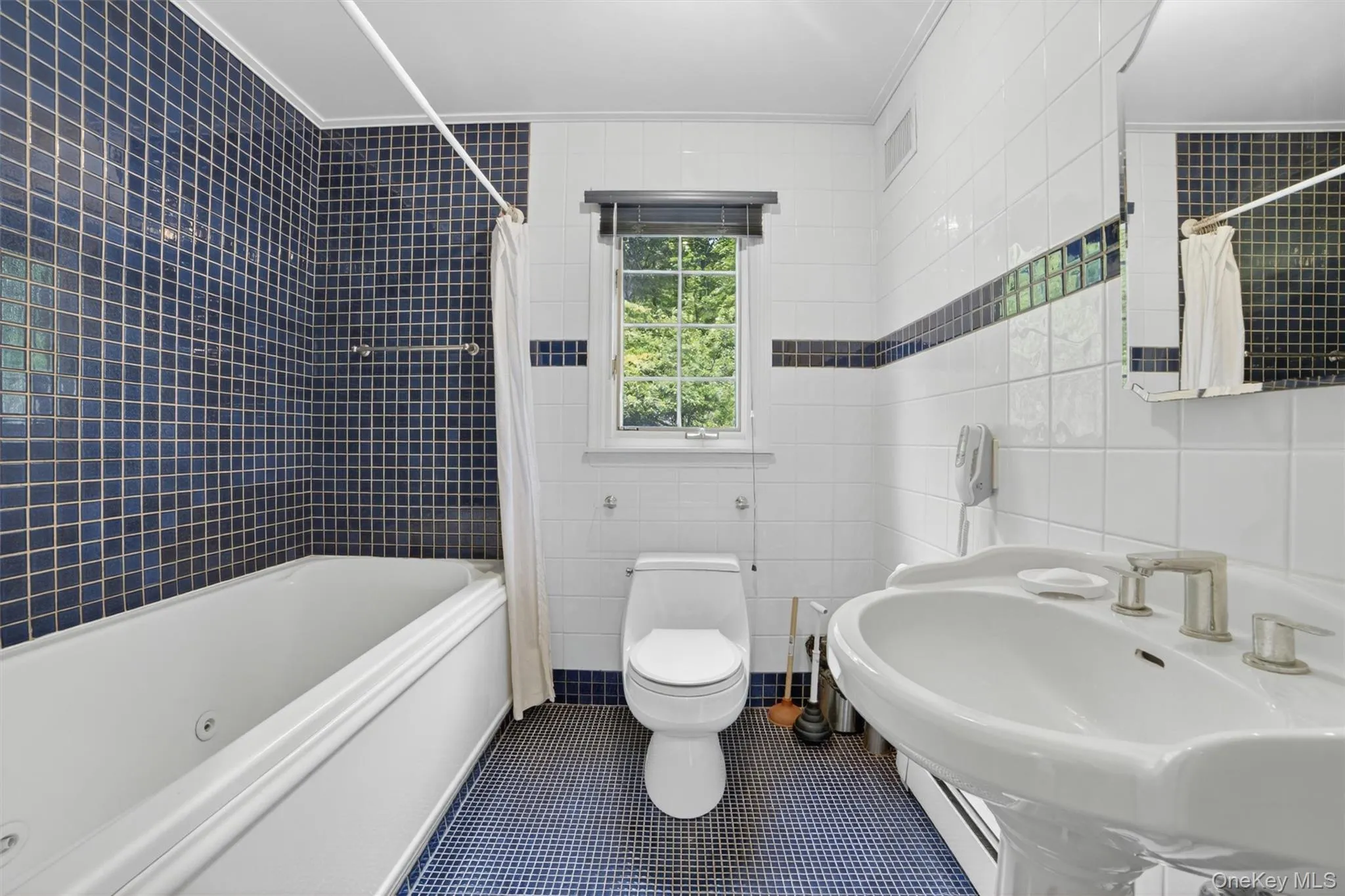 Main floor full hall bathroom offering a functional layout with classic finishes and convenient access from the main living areas. Main floor full hall bathroom offering a functional layout with classic finishes and convenient access from the main living areas.