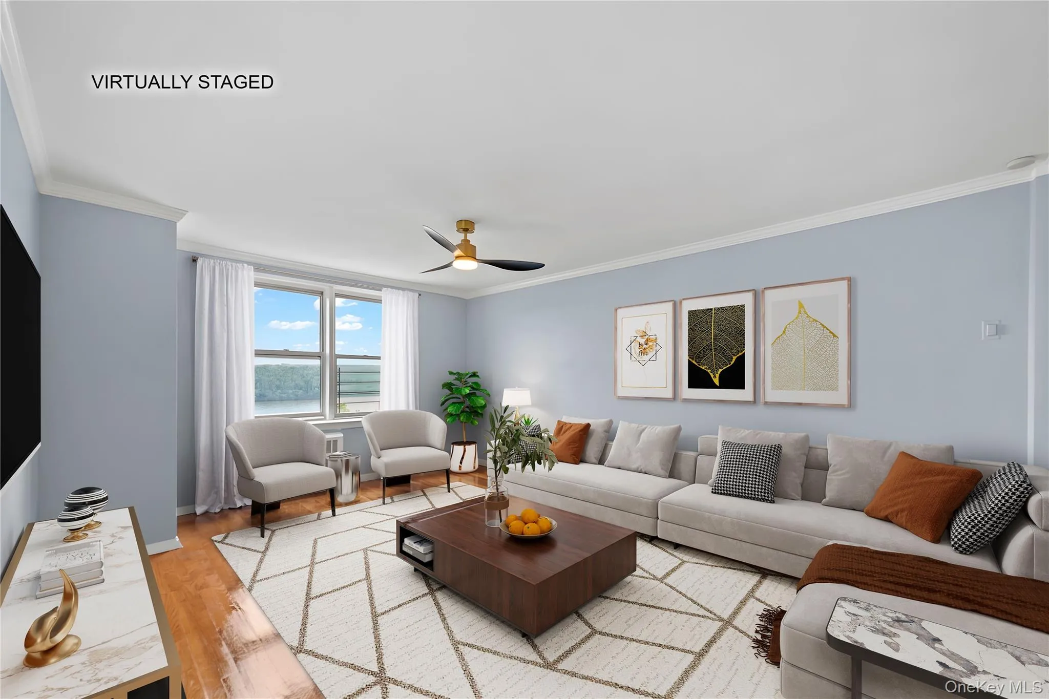 Spacious living area featuring light blue walls, wood-finish flooring, and crown molding Spacious living area featuring light blue walls, wood-finish flooring, and crown molding