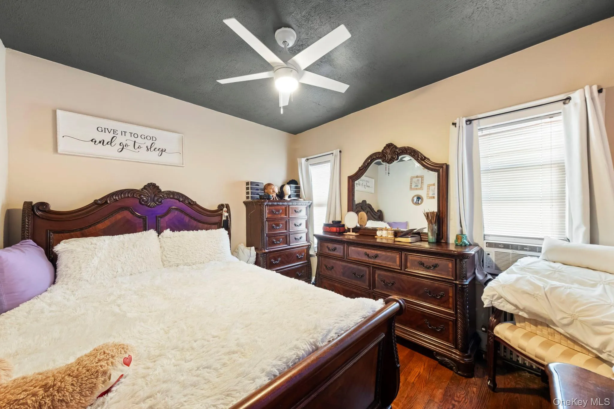 Bedroom featuring light-toned walls, a dark ceiling, and a ceiling fan with integrated lighting Bedroom featuring light-toned walls, a dark ceiling, and a ceiling fan with integrated lighting