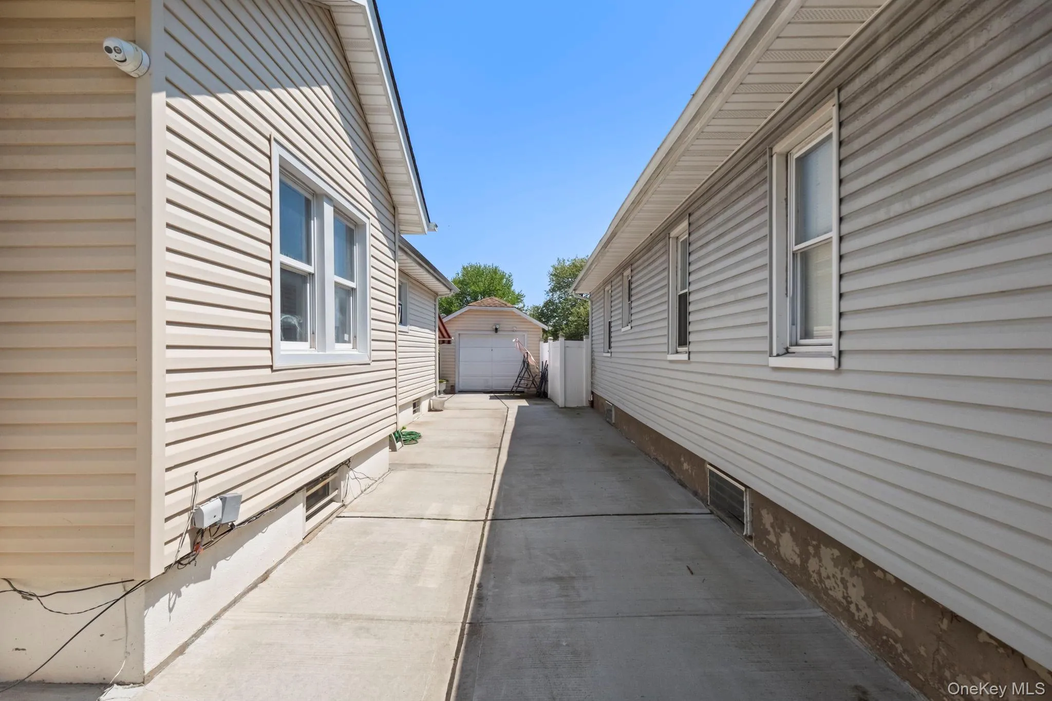 Concrete driveway leading to a detached garage Concrete driveway leading to a detached garage
