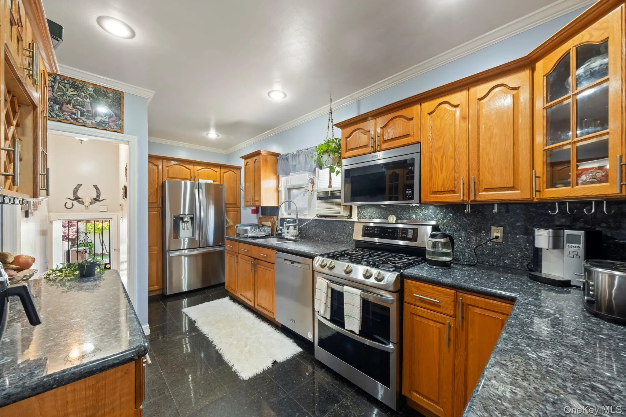 Kitchen featuring wood cabinetry, dark granite countertops, stainless steel appliances, and recessed lighting Kitchen featuring wood cabinetry, dark granite countertops, stainless steel appliances, and recessed lighting