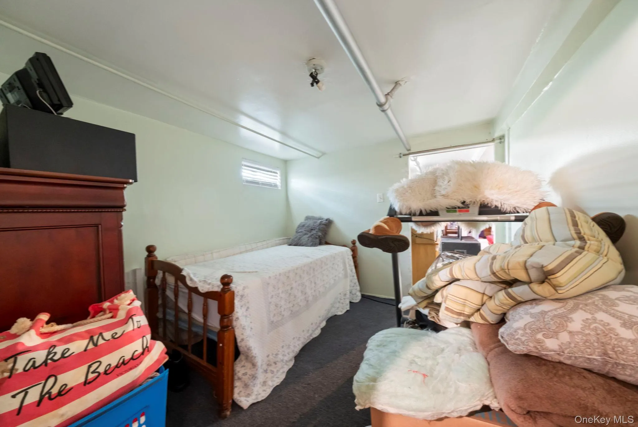 Carpeted room downstairs with light green walls and a small horizontal window Carpeted room downstairs with light green walls and a small horizontal window