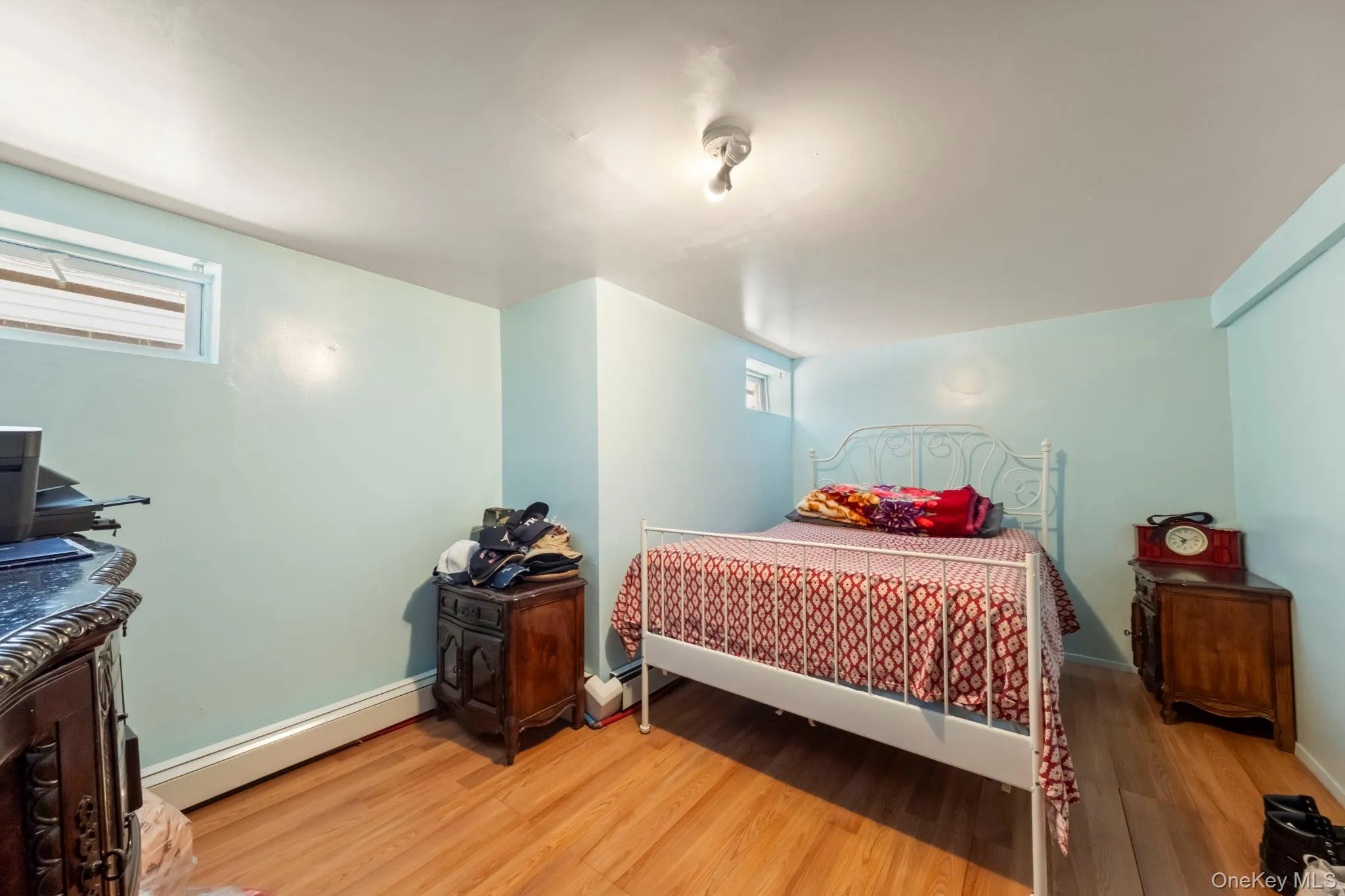 Room featuring wood-finish flooring, light blue painted walls, and white trim Room featuring wood-finish flooring, light blue painted walls, and white trim