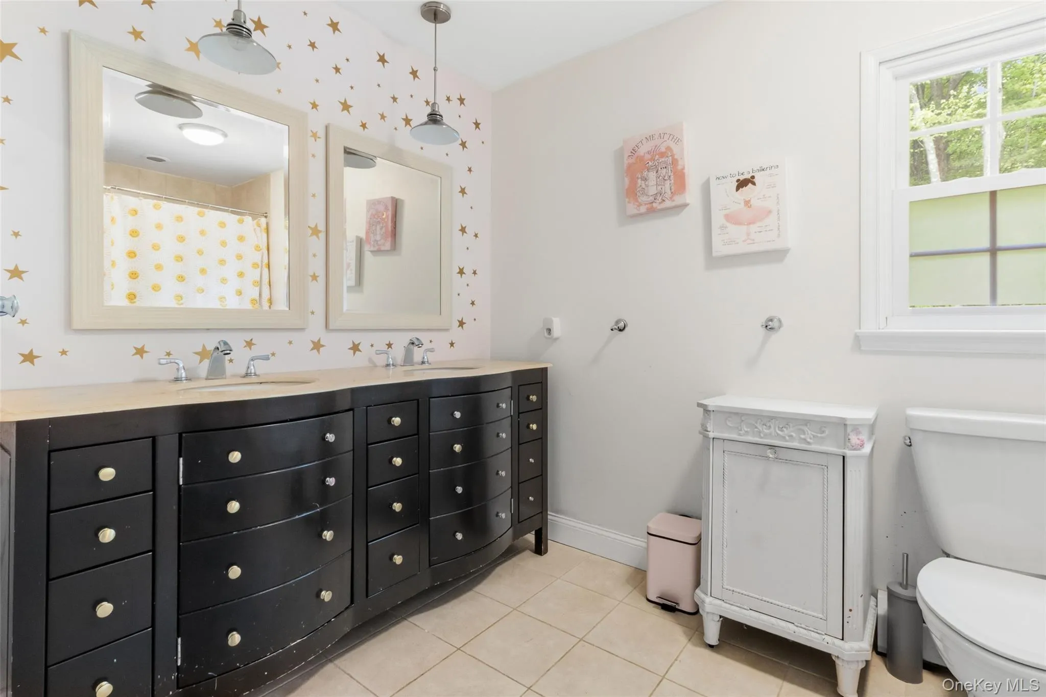 Double vanity with integrated sinks, light-toned countertop, and dual framed mirrors Double vanity with integrated sinks, light-toned countertop, and dual framed mirrors