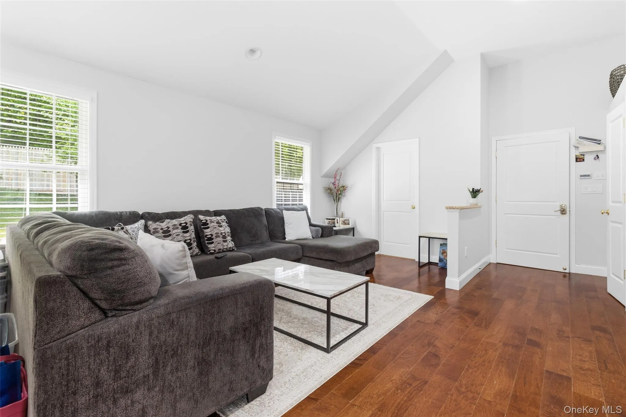 Accessory Unit Living area featuring hardwood flooring, multiple windows providing natural light, a vaulted ceiling, and white panel doors Accessory Unit Living area featuring hardwood flooring, multiple windows providing natural light, a vaulted ceiling, and white panel doors