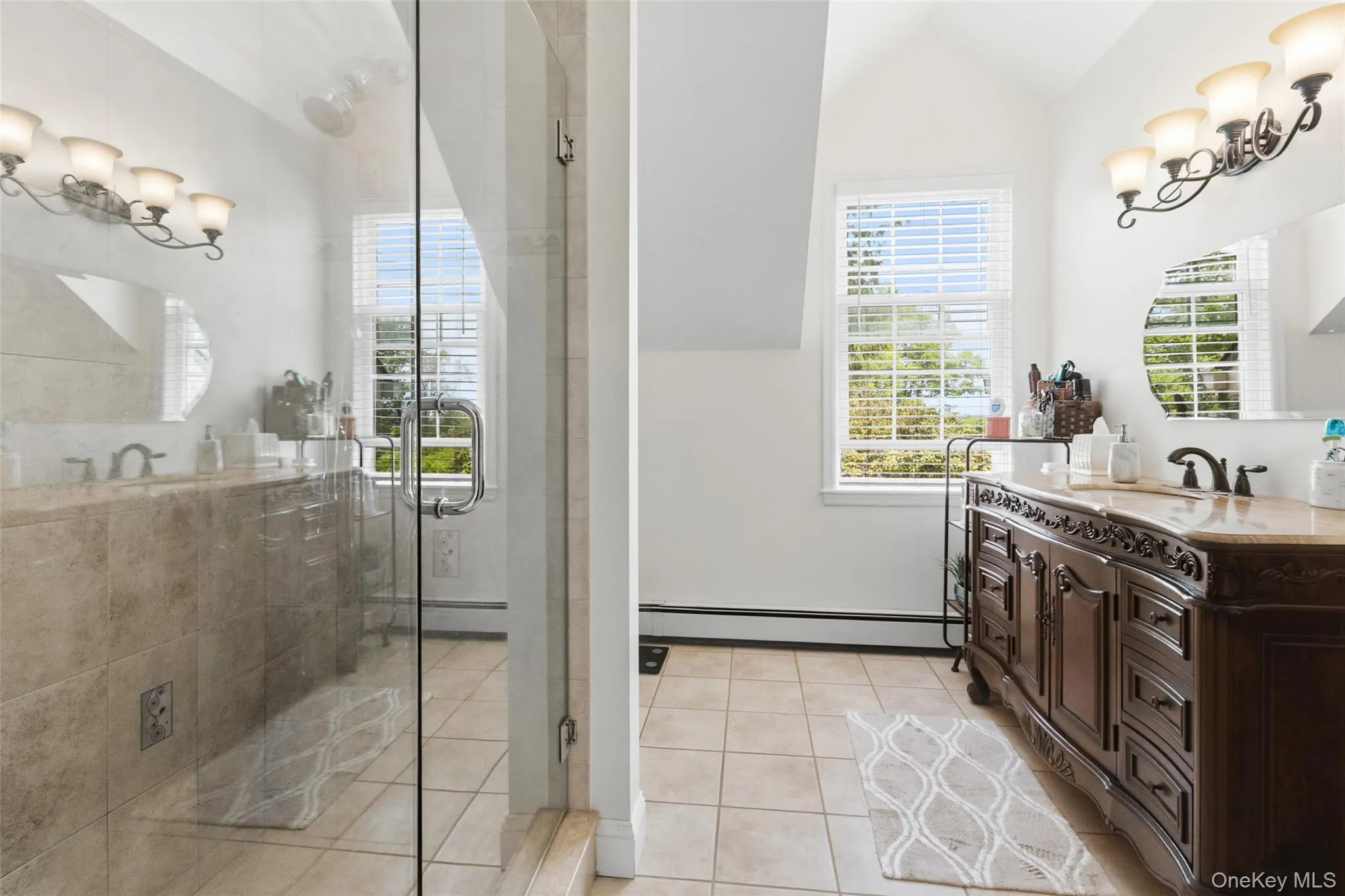 Glass-enclosed shower with a chrome handle, featuring tile walls and flooring Glass-enclosed shower with a chrome handle, featuring tile walls and flooring