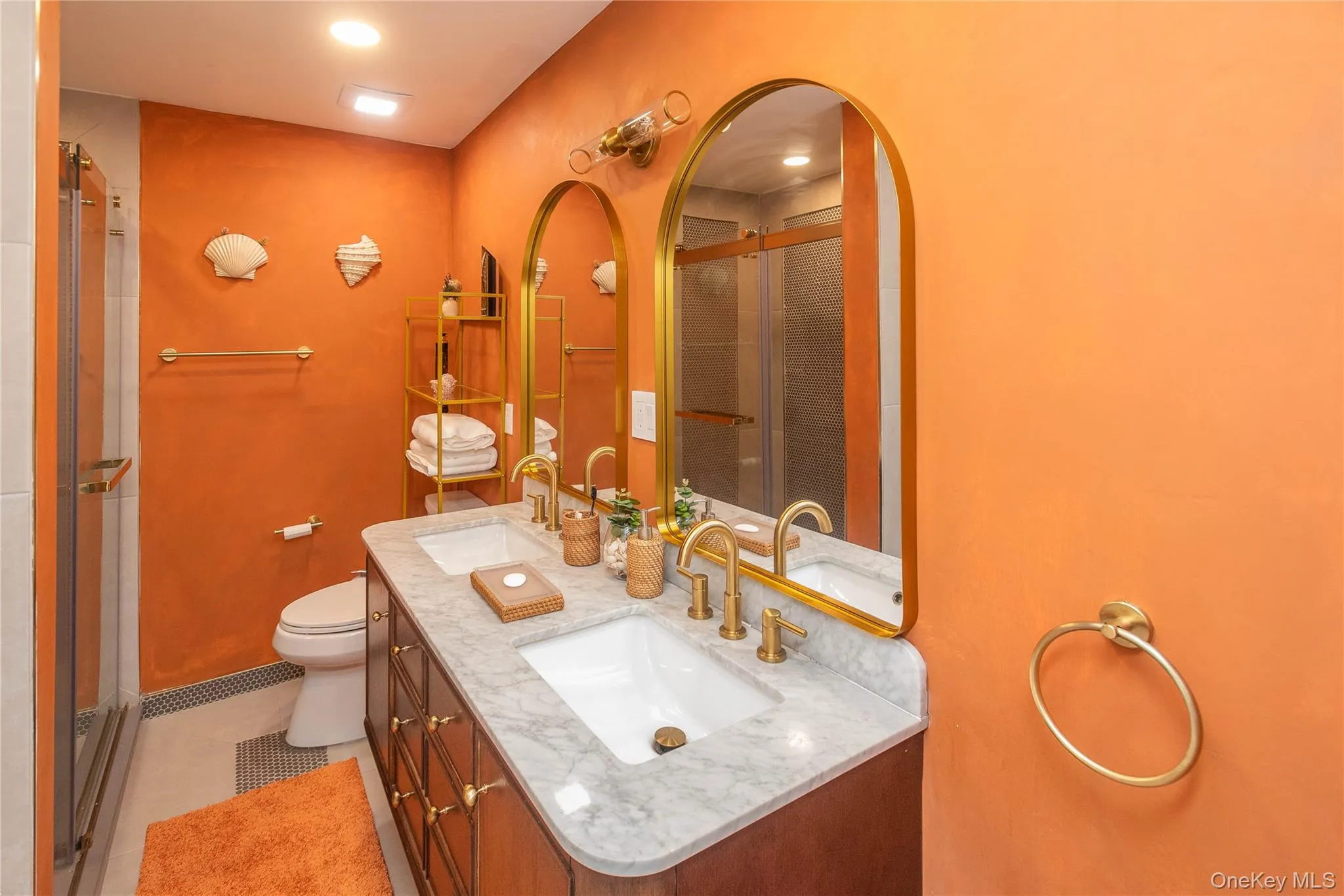 Full bathroom with a stall shower, double vanity, toilet, and tile patterned flooring Full bathroom with a stall shower, double vanity, toilet, and tile patterned flooring